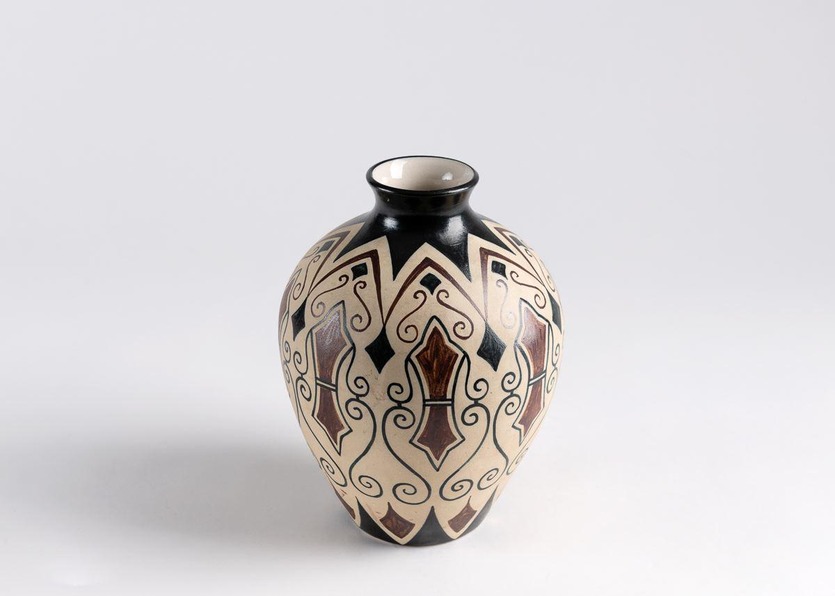 A beautiful ceramic from Ciboure Pottery, this piece was executed by Garcia de Diego, and features a repeating pattern of abstract designs in various shades of tan, brown, and black.

Signed: GARCI´A
Stamped with foundry mark: R. F. CIBOURE.