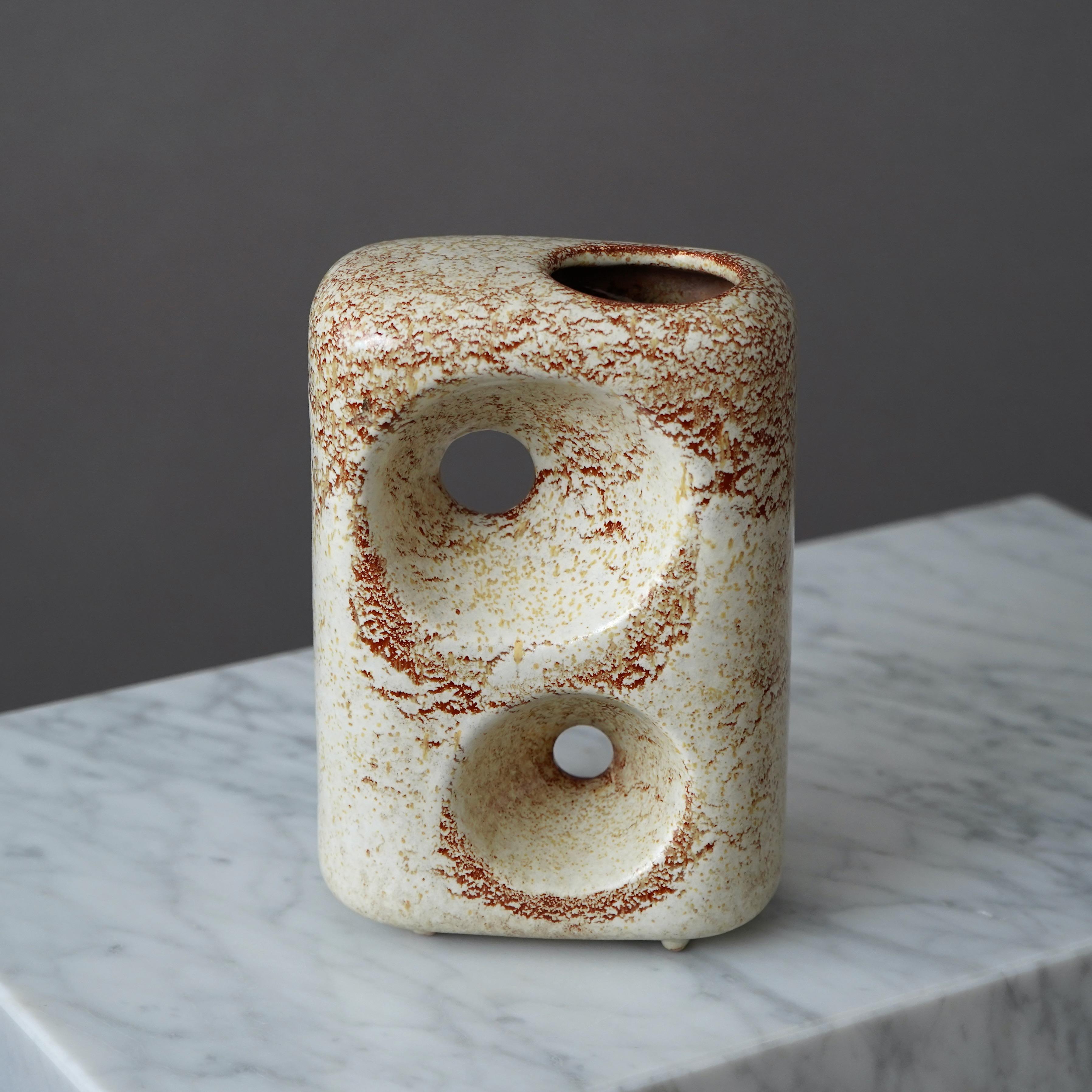 An extraordinarily sculptural biomorphic vase designed by Roberto Rigon for Bertoncello Ceramiche D'Arte, Italy.  It is clad in Bertoncello's typical creamy colored 'Screziato Havana' glaze and is raised on three shallow feet, giving the vase the