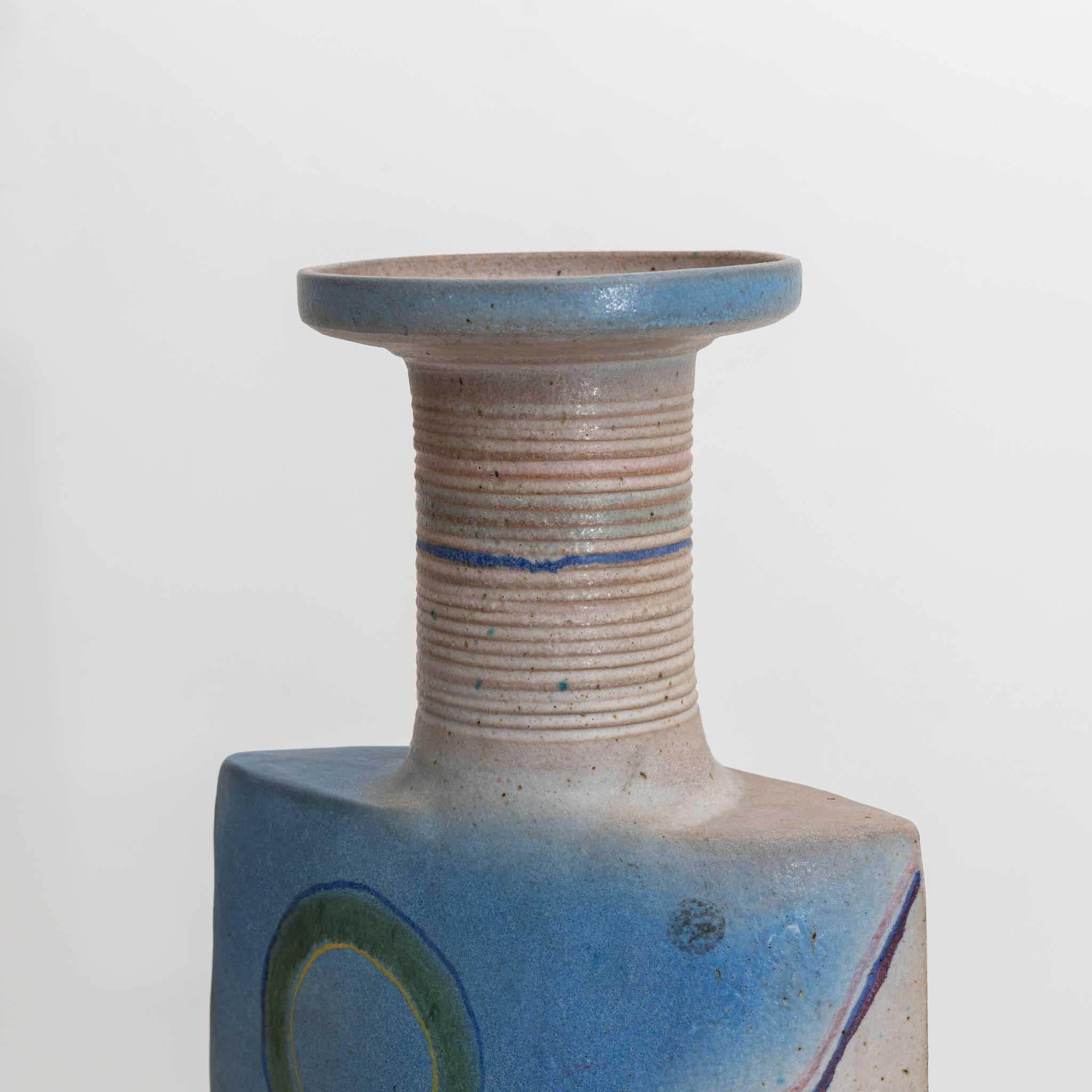 Large vase with trapezoidal curved wall and cylindrical neck with wide lip. The vase is made of ceramic and has a blue décor.