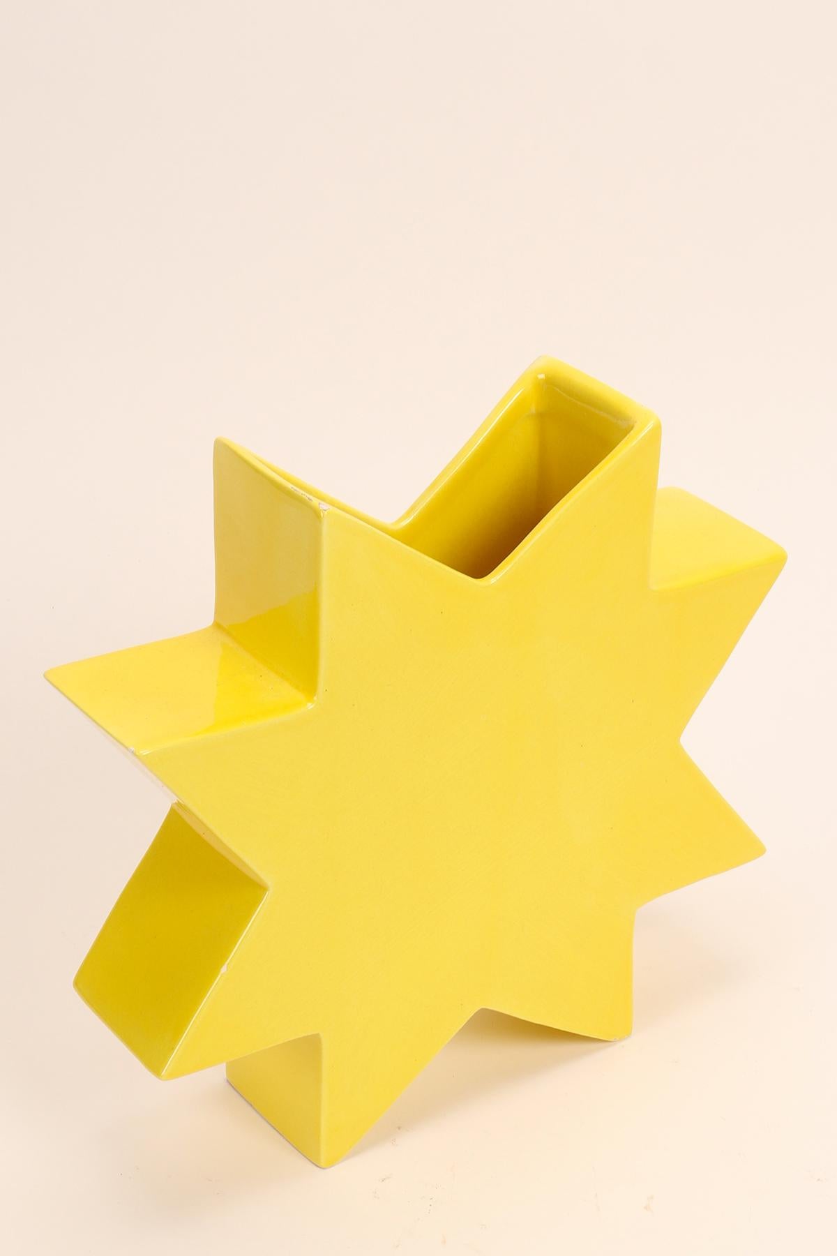 Bemalte Keramikvase Memphis Milano, Csillag von Luciano Florio Paccagnella, gelbe Farbe.
Er war ein wichtiges Mitglied der Gruppe, als er seine Serie von einzigartigen handgefertigten Vasen schuf. Florio Paccagnella studierte Werbegrafik am Liceo