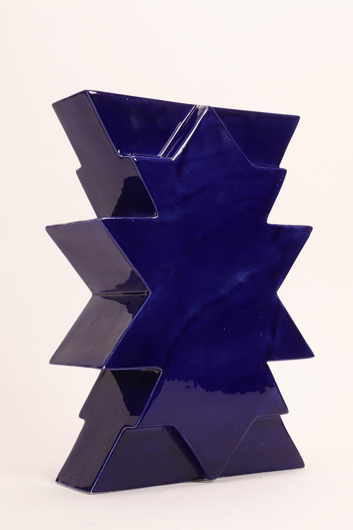 Bemalte Keramikvase Memphis Milano, Ilios von Luciano Florio Paccagnella, Farbe blau.
Er war ein wichtiges Mitglied der Gruppe, als er seine Serie von einzigartigen handgefertigten Vasen schuf. Florio Paccagnella studierte Werbegrafik am Liceo
