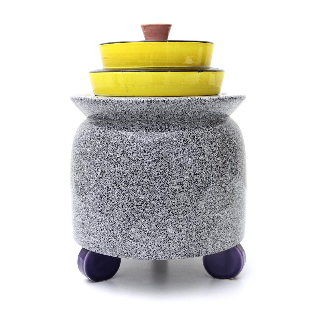 Ceramic object holder made by Baldelli in the 1980s.
Main body in grey color, resting on three purple colored feet.

Yellow and black cap with pink knob.
Good general conditions, one leg has been repaired.
Dimensions: Diameter 19 cm - Height 27