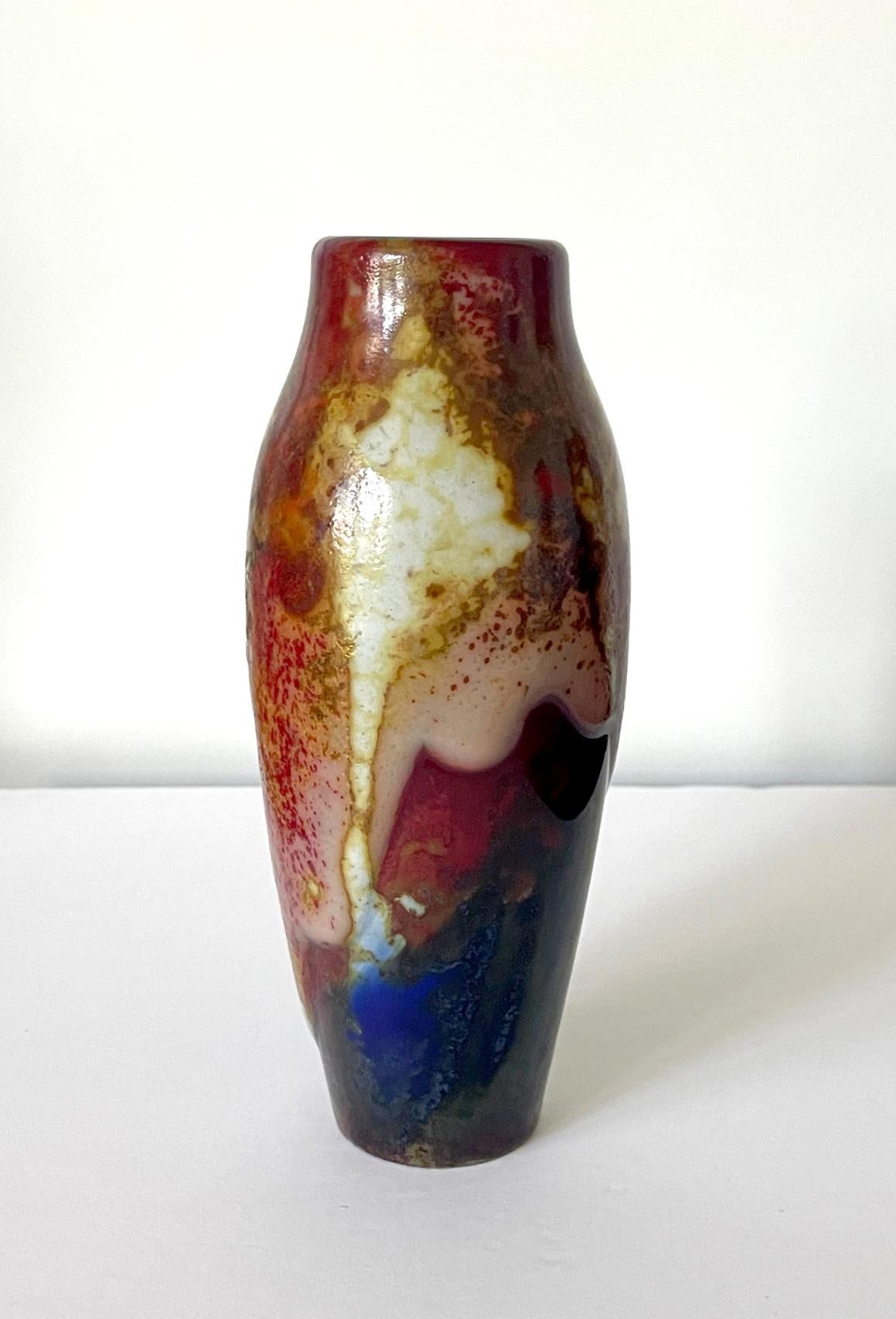 A glazed ceramic vase in slender spindle form from the Chang Ware series by Royal Doulton (England, founded 1815) circa 1920-30s. The vase was decorated with thick and dripping glaze in rich mottled polychrome colors. The glaze shows overall