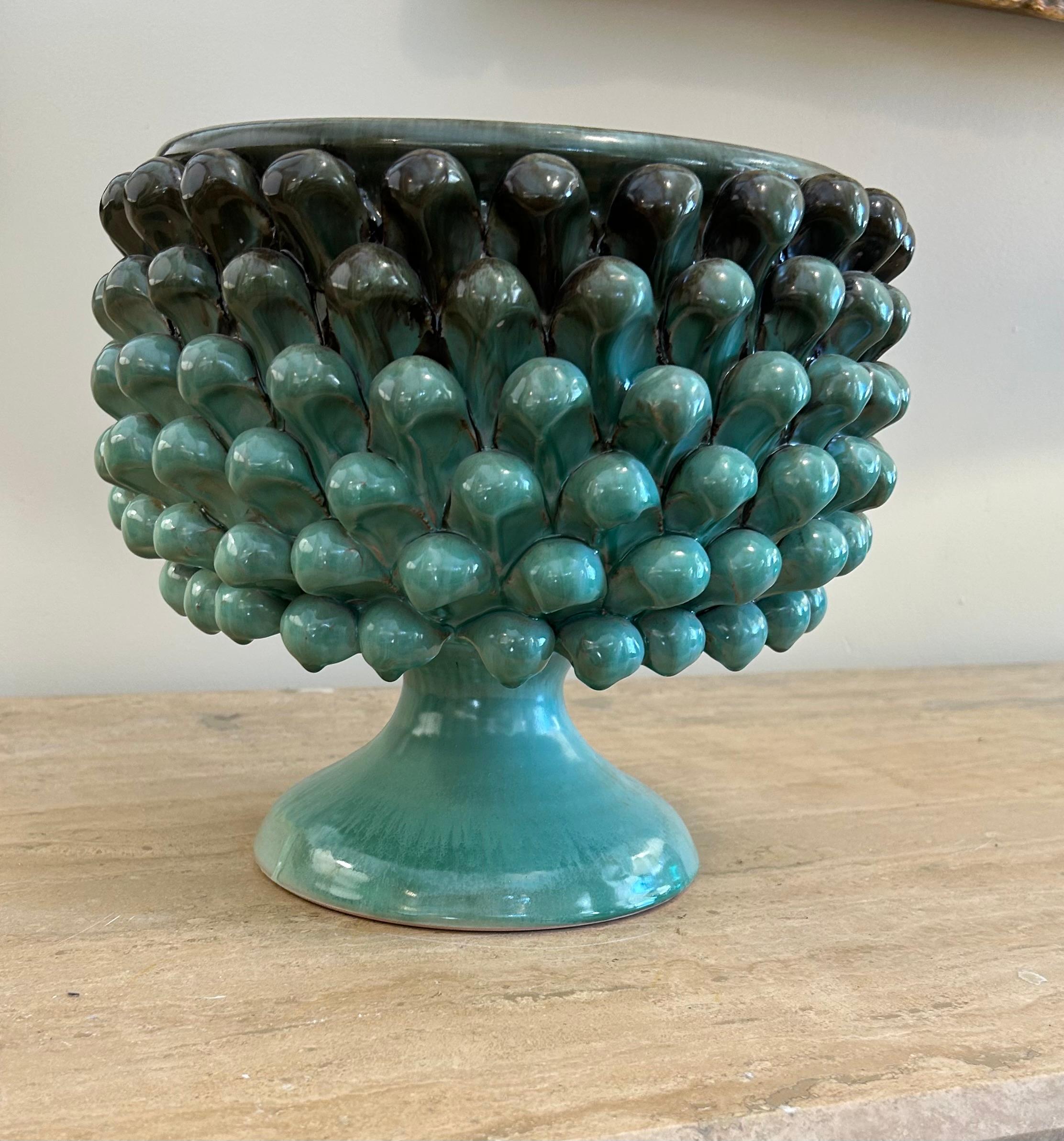 Vase décoratif ou bol sur pied en céramique émaillée.

Structure en forme de calice : Une forme évasée reposant sur un pied conique, ce qui lui confère une silhouette élégante et sculpturale.
• Le corps est entièrement décoré de motifs en relief