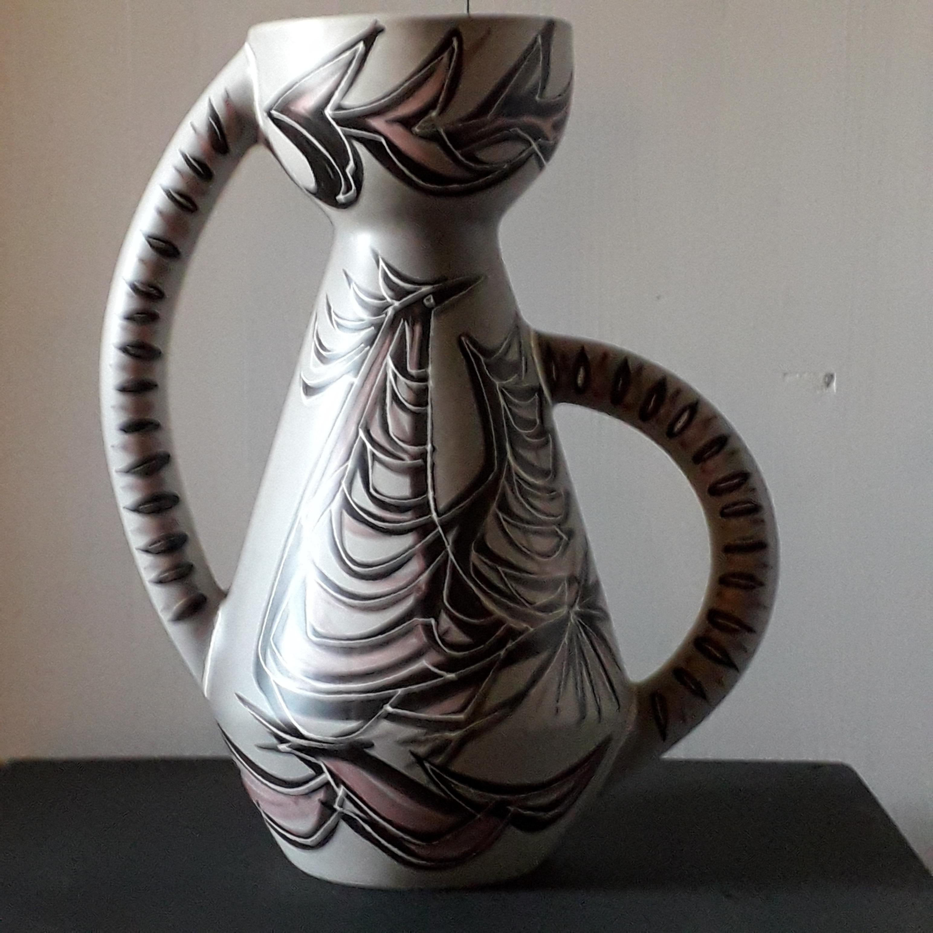 Large vase with double handle in ceramic, stylized rooster decoration on a gray background in the style of Hélène Ugo.
Signed by the artist, GB Vallauris Ghislaine Bélio ceramist in the 2000s.
Measures: Height 40 cm / diameter 33 cm.
In excellent