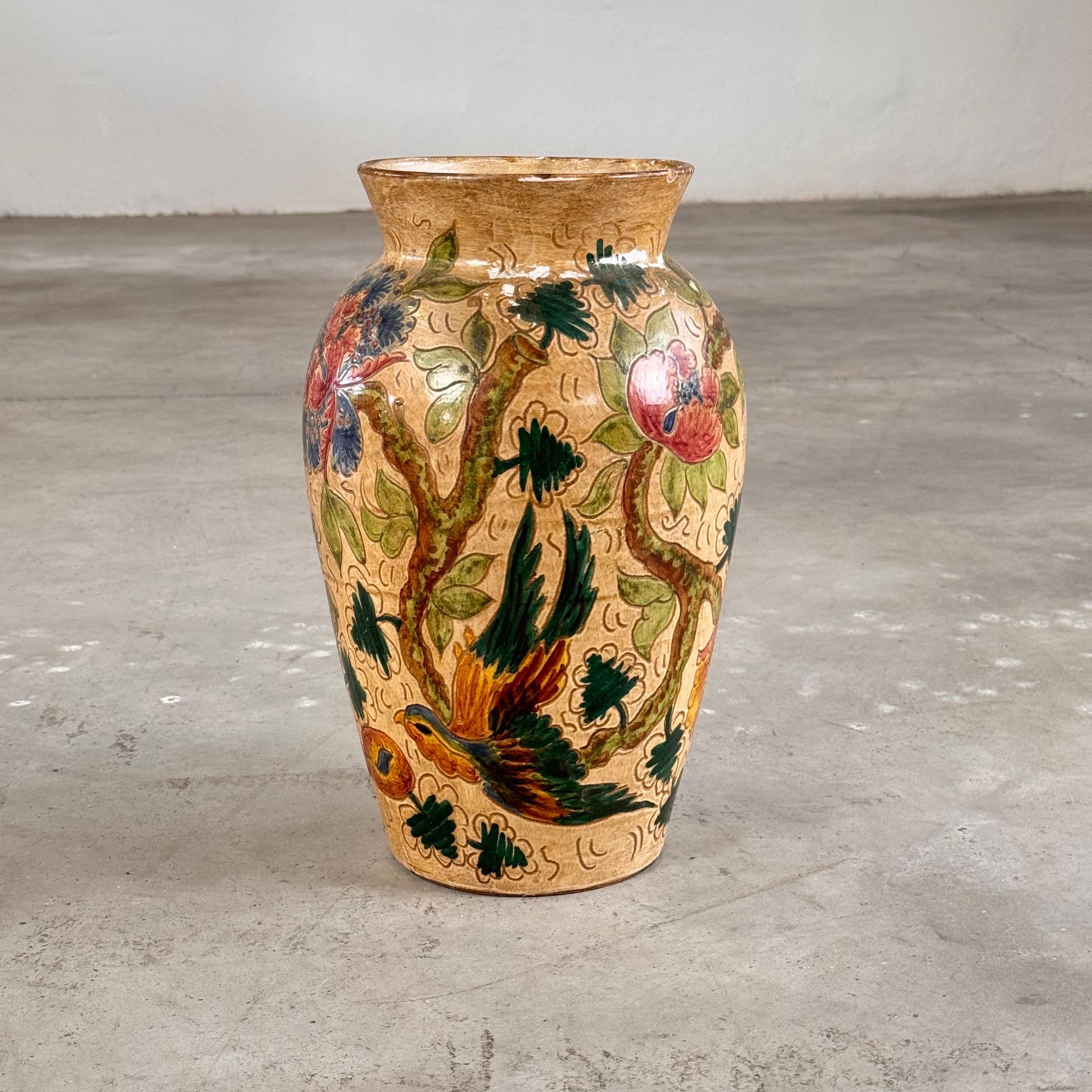 Este impresionante jarrón grande de cerámica, fabricado y pintado a mano por C. Monarchi en Gubbio (Italia) durante la década de 1930, encarna la refinada elegancia del movimiento Art Déco. Con intrincados motivos florales y de pájaros en colores