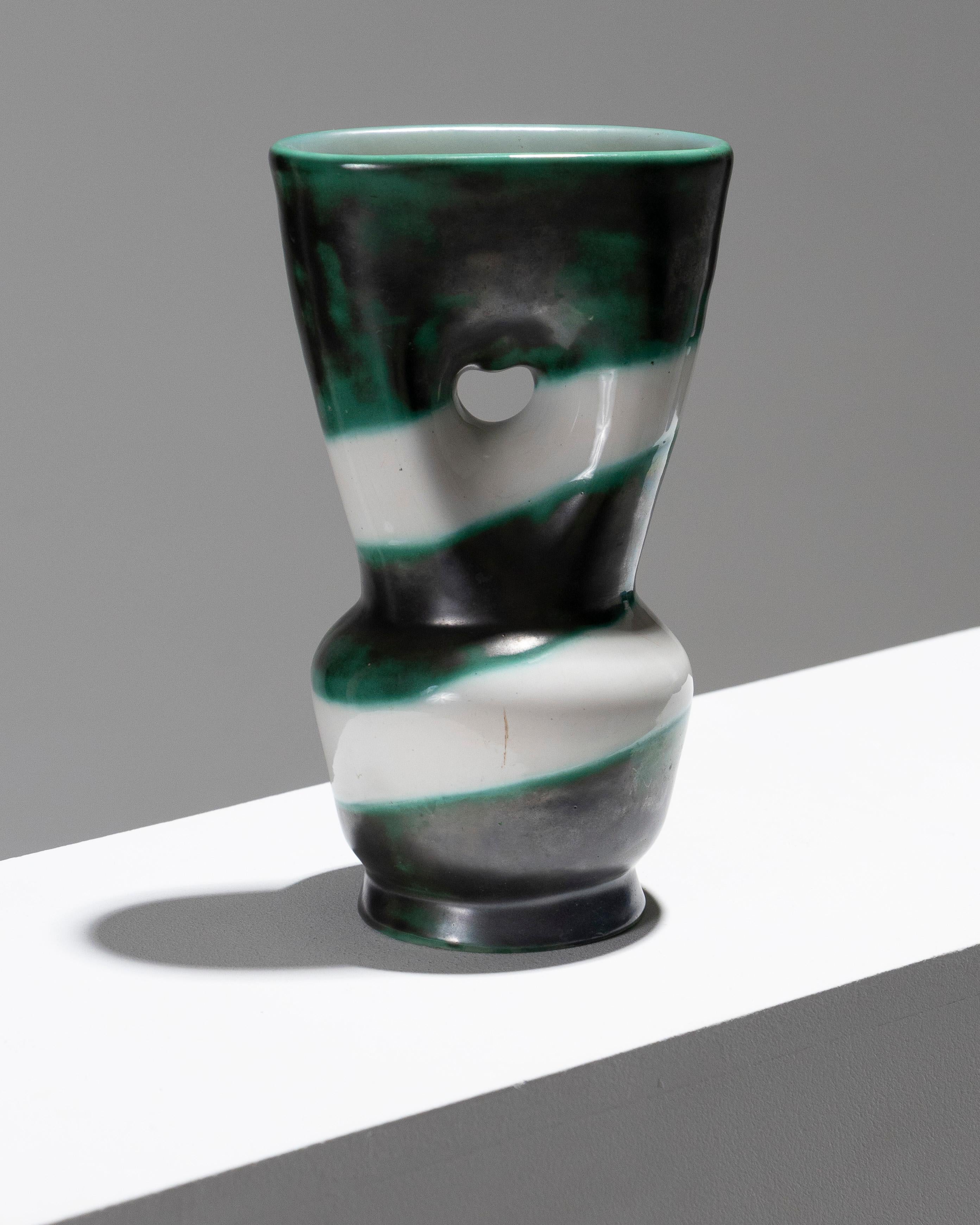 Vaso sferico in ceramica con collo alto e appiattito e foro centrale, realizzato dal ceramista francese Henri Milet negli anni Sessanta. Caratterizzato da un motivo diagonale di strisce verdi leggermente metallizzate su uno sfondo bianco smaltato.