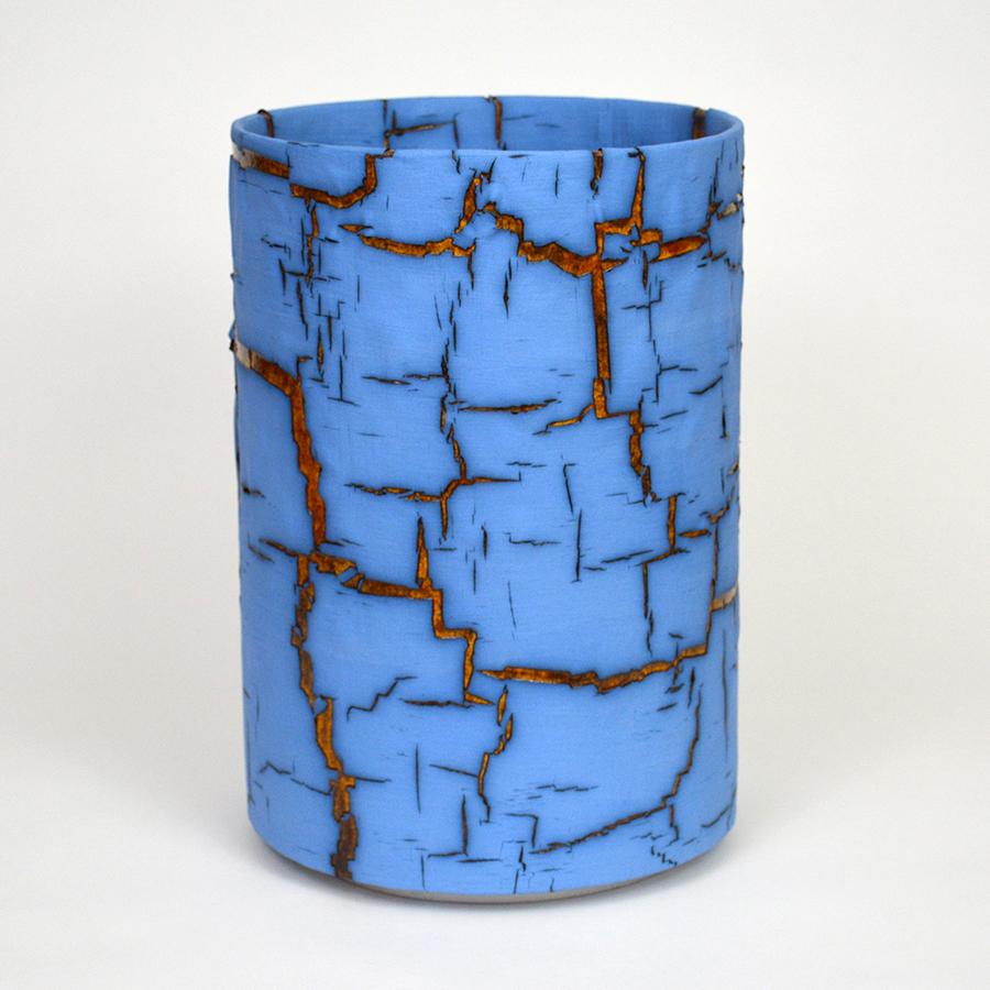 Glazed ceramic cylindrical sculpture by William Edwards
Hand built earthenware vessel, fired multiple times to achieve a textured surface of random abstraction, Blue matte with amber gloss glaze breaking through.

William received his BFA in