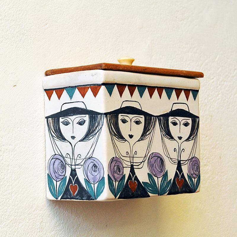 Lovely hand painted ceramic wall container box designed by Laila Zink for Kupittaan Savi  Finland in the 1960s. Perfect storage for sugar, flour, grains etc in the kitchen - or why not a pencil holder or planter on the wall? Handpainted women with