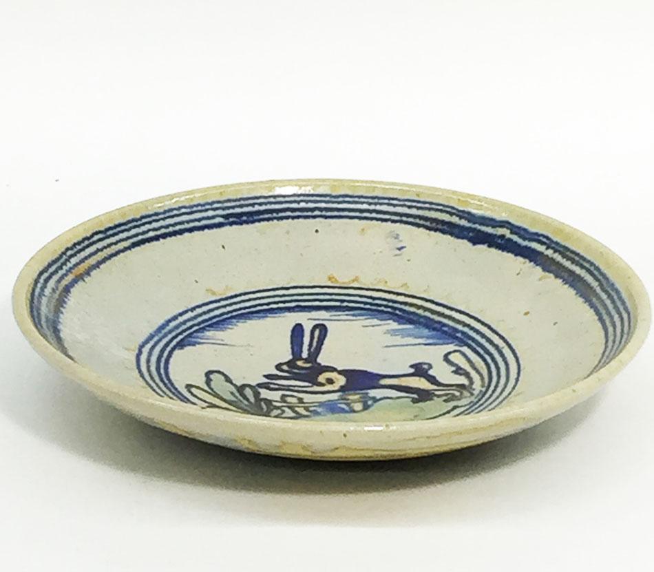 Ceramic wall dish by Chris. J. Lanooy (1881-1948) 

A wall dish from the early 20th century with decoration of a leaping hare in a landscape in a blue 4 row circle in the middle and on the edge

The rim has minor damage to the edge on the
