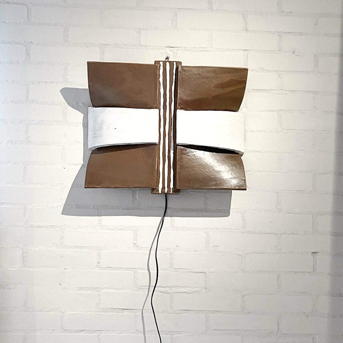 This ceramic wall light, created circa 1975 by German artist Walburga Kulz (b. 1931), exemplifies her ability to blend sculptural artistry with functional design. Featuring bold geometric shapes in earthy brown and white tones, the piece offers a