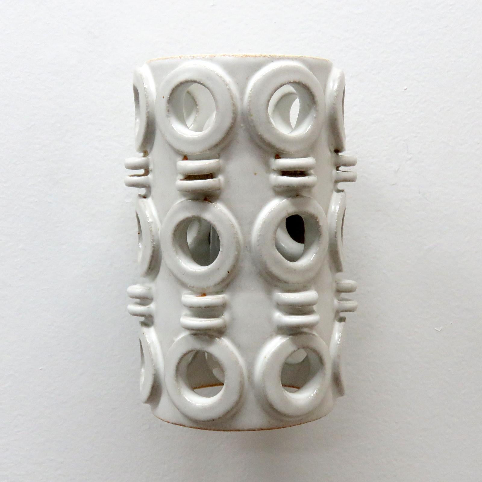 Maravilloso aplique escultórico de cerámica nº 49, diseñado y fabricado a mano por la ceramista Heather Levine, afincada en Los Ángeles. Gres de alta cocción con cuerpo de esmalte gris/blanco con perforaciones decorativas para exponer la luz en