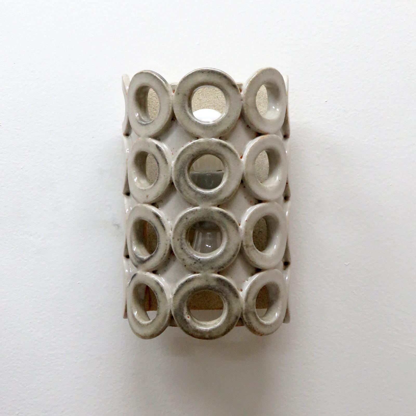 wonderfully sculptural ceramic wall lights No.50b, designed and handcrafted by Los Angeles based ceramicist Heather Levine. High fired stoneware with grey and black accents glaze body with decorative perforations to expose light in patterns on