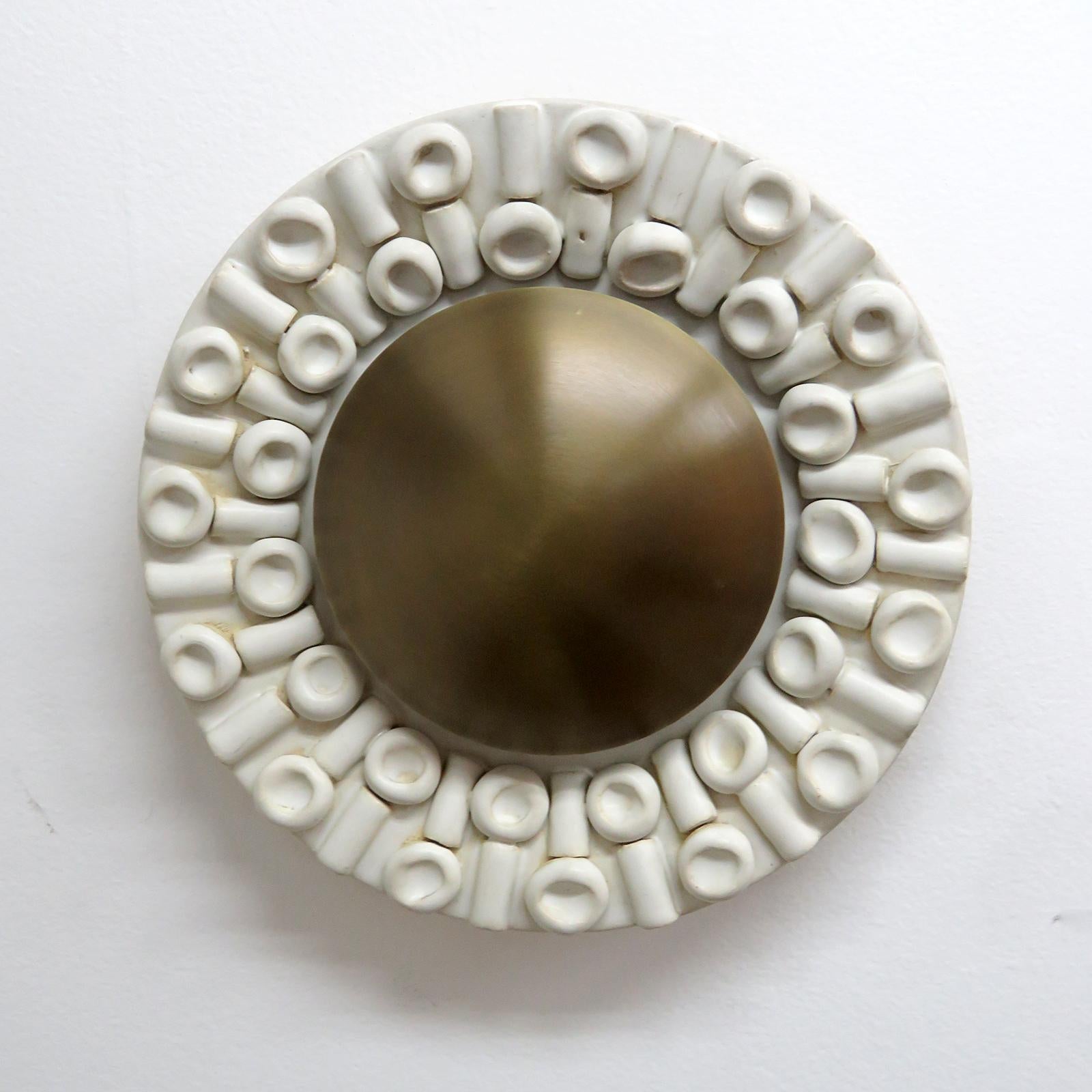 wonderfully sculptural ceramic wall lights No.C52, designed and handcrafted by Los Angeles based ceramicist Heather Levine. High fired stoneware with milky white glaze on a dark brown clay body with decorative textures and an aged brass circular