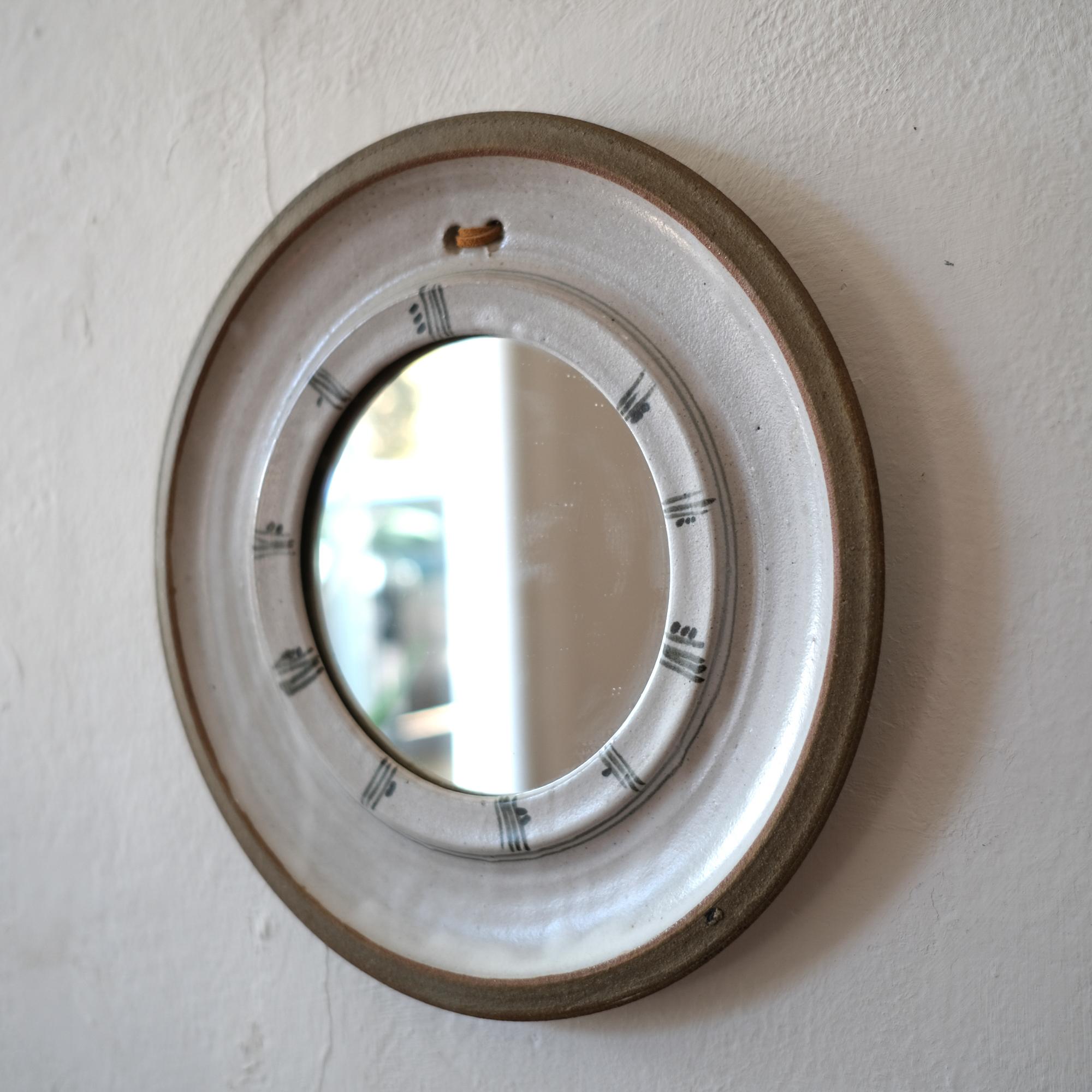Hand thrown ceramic mirror, with leather hanger, 1960s.