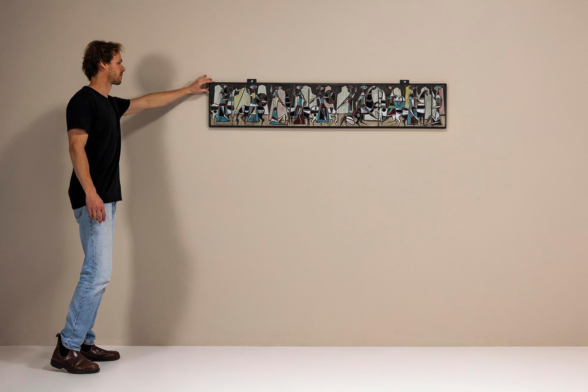 Ce panneau mural horizontal en céramique de Marcello Fantoni capture un récit visuel enraciné dans la procession antique et l'abstraction moderne du milieu du siècle. D'une longueur de plus d'un mètre et demi, cette œuvre illustre la fusion