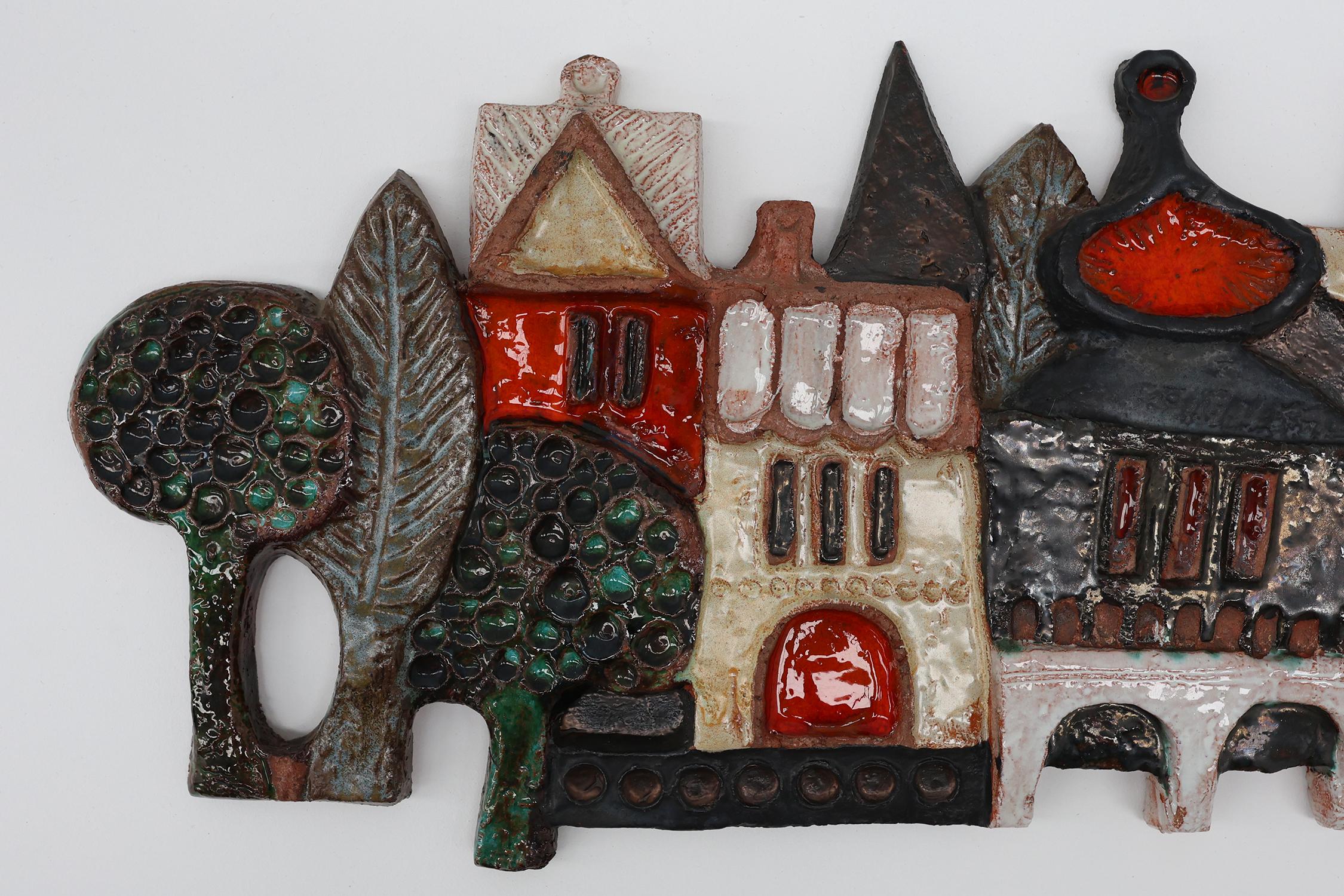 Belgium / 1960 / / Plaquette city view / Amphora / Elisabeth Vandeweghe / ceramics / Mid-century / Vintage

Vintage wall mounted ceramic plaquette by Elisabeth Vandeweghe for Amphora featuring a a colourful village scene with striking red and black