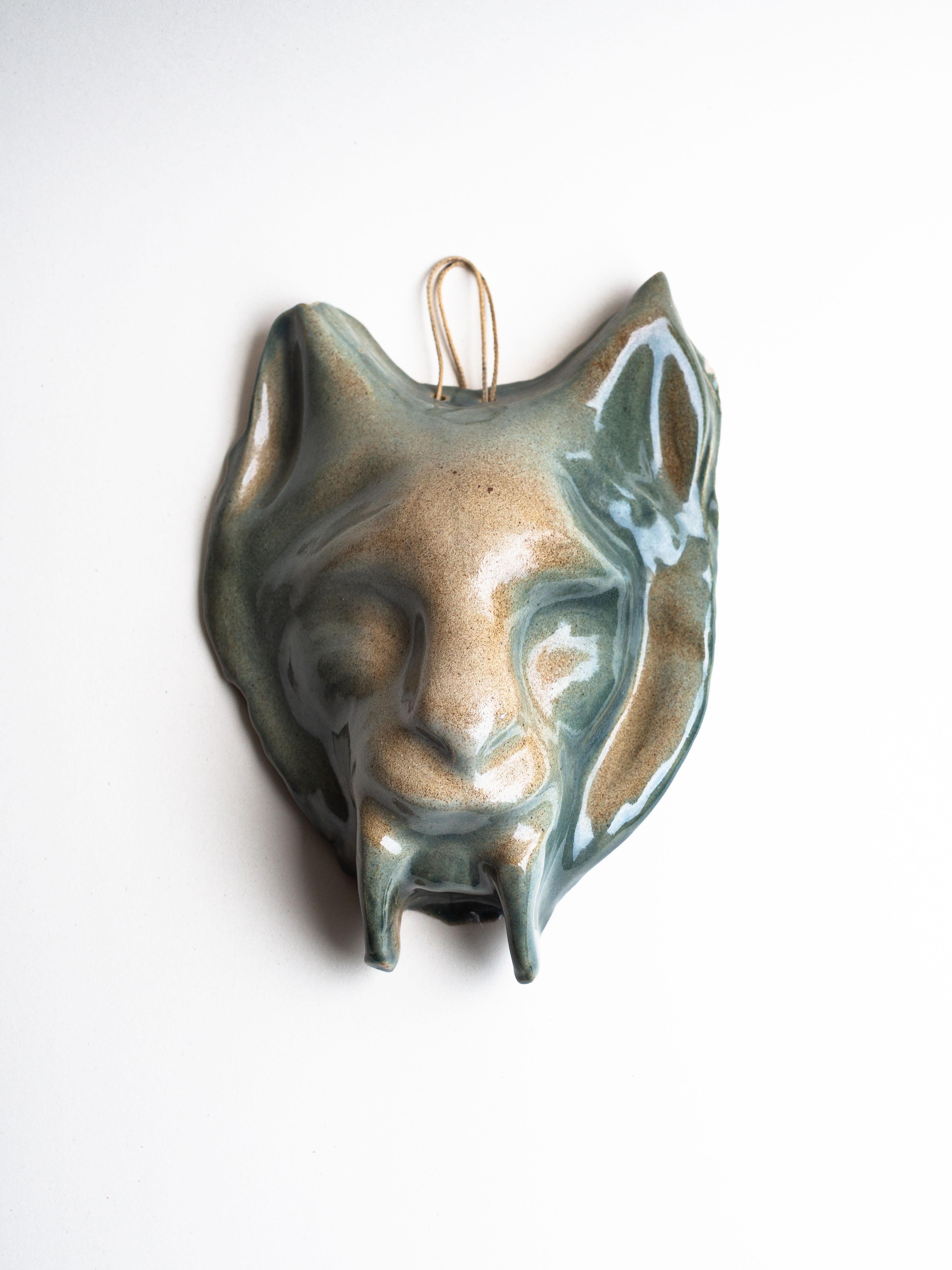 Ceramic Wall Sculpture, Zoomorphic Feline Mask, France 1970s.

This unique, hand-crafted ceramic wall mask is an original, figurative piece depicting a feline, reminiscent of a fantastical and dreamlike creature. 

The glossy glaze features shades