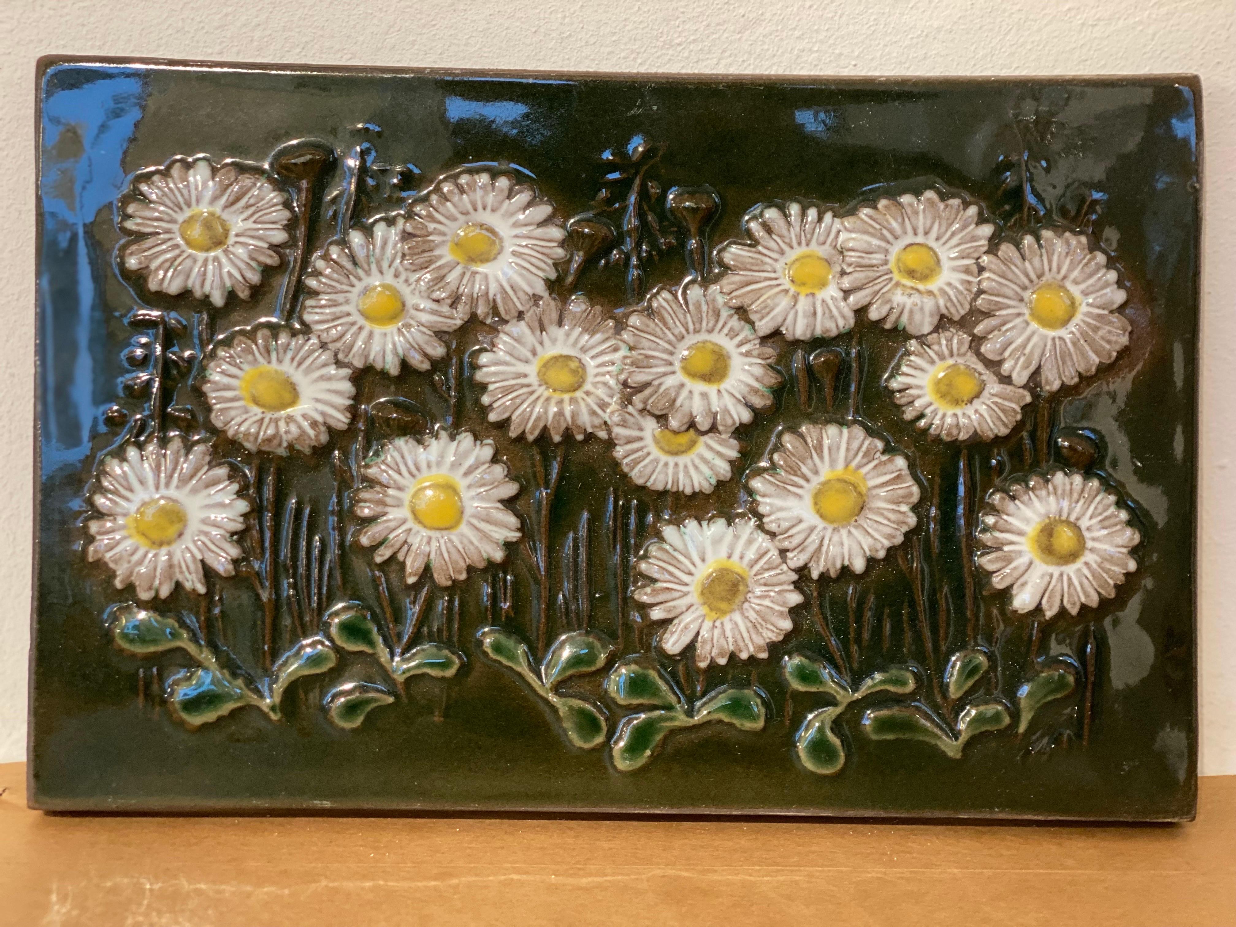 This beautiful wall plaque with daisies is a part of the series various flowers, they are made of stoneware and hand painted. They have a glass coating. Designed by Aimo Nietosvuori for JIE Gantofta. Finnish designer who moved to Sweden. In the