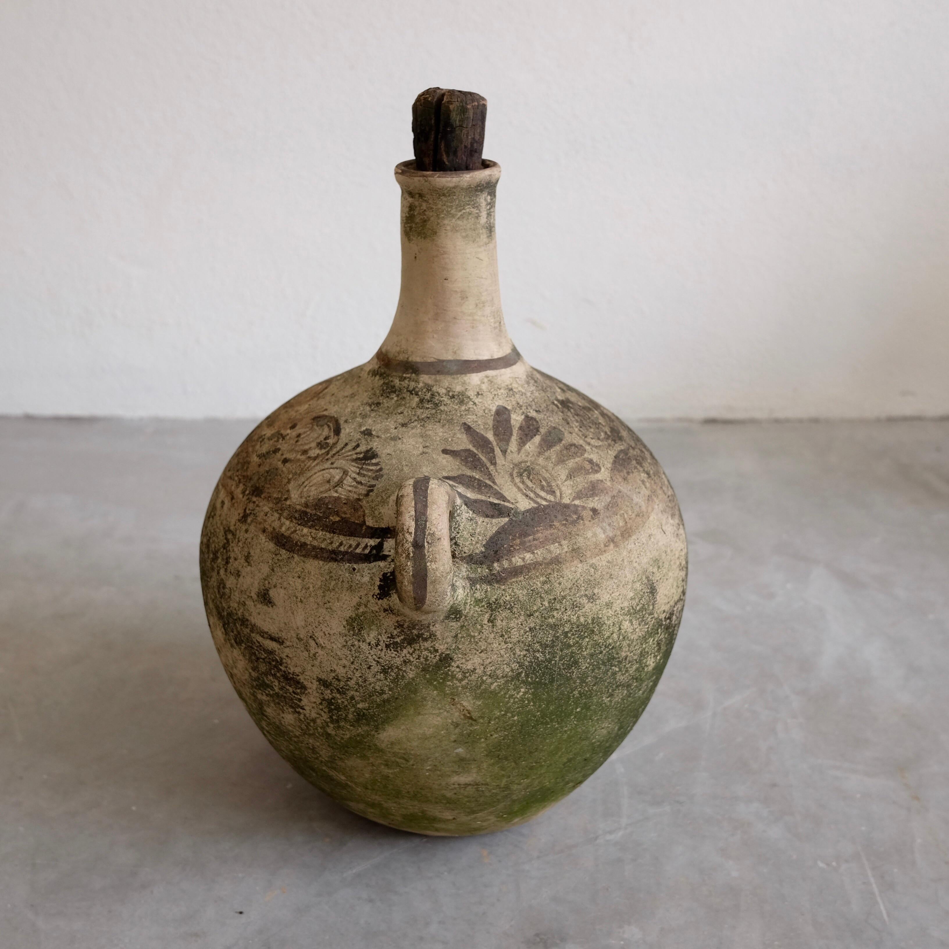 Long-neck vessel from Chililico, Hidalgo with original wood stopper. The jug has been lightly washed and what remains is the moss as seen in the photos. The pot was painted using a natural earth dye and feathers. The piece is a nice representation