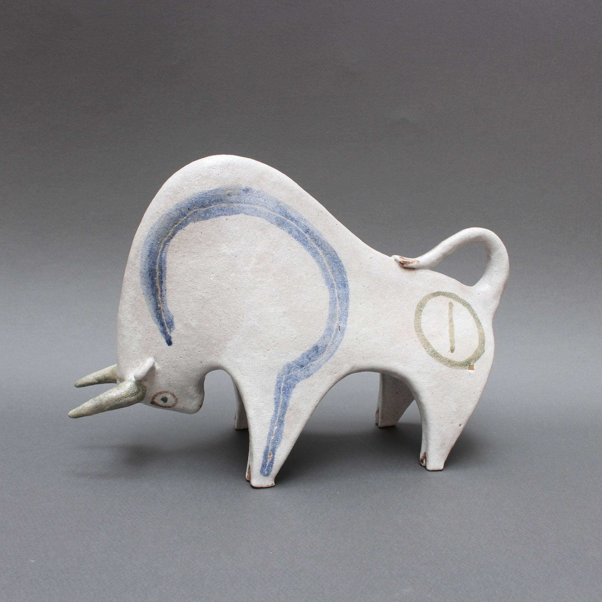 Ceramic decorative bull by Bruno Gambone, (circa 1970s). This is a piece from Gambone's series of chalk-white ceramic animal sculptures. A charging bull with blue lines highlighting the large torso. A playful circle with line - a sort of bullseye -