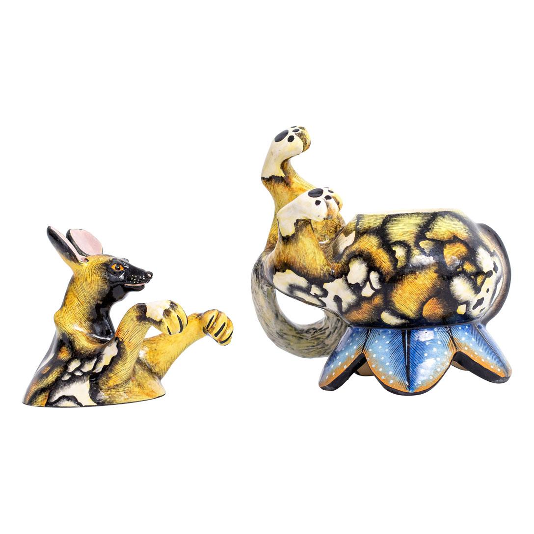 Crafted by Love Art Ceramic in South Africa, this ceramic Wild Dog jewelry box is a testament to indigenous craftsmanship. Standing 6 inches high, 3 inches long, and 3 inches wide, it features the exquisite handiwork of Nozipho Ntshalintshali's
