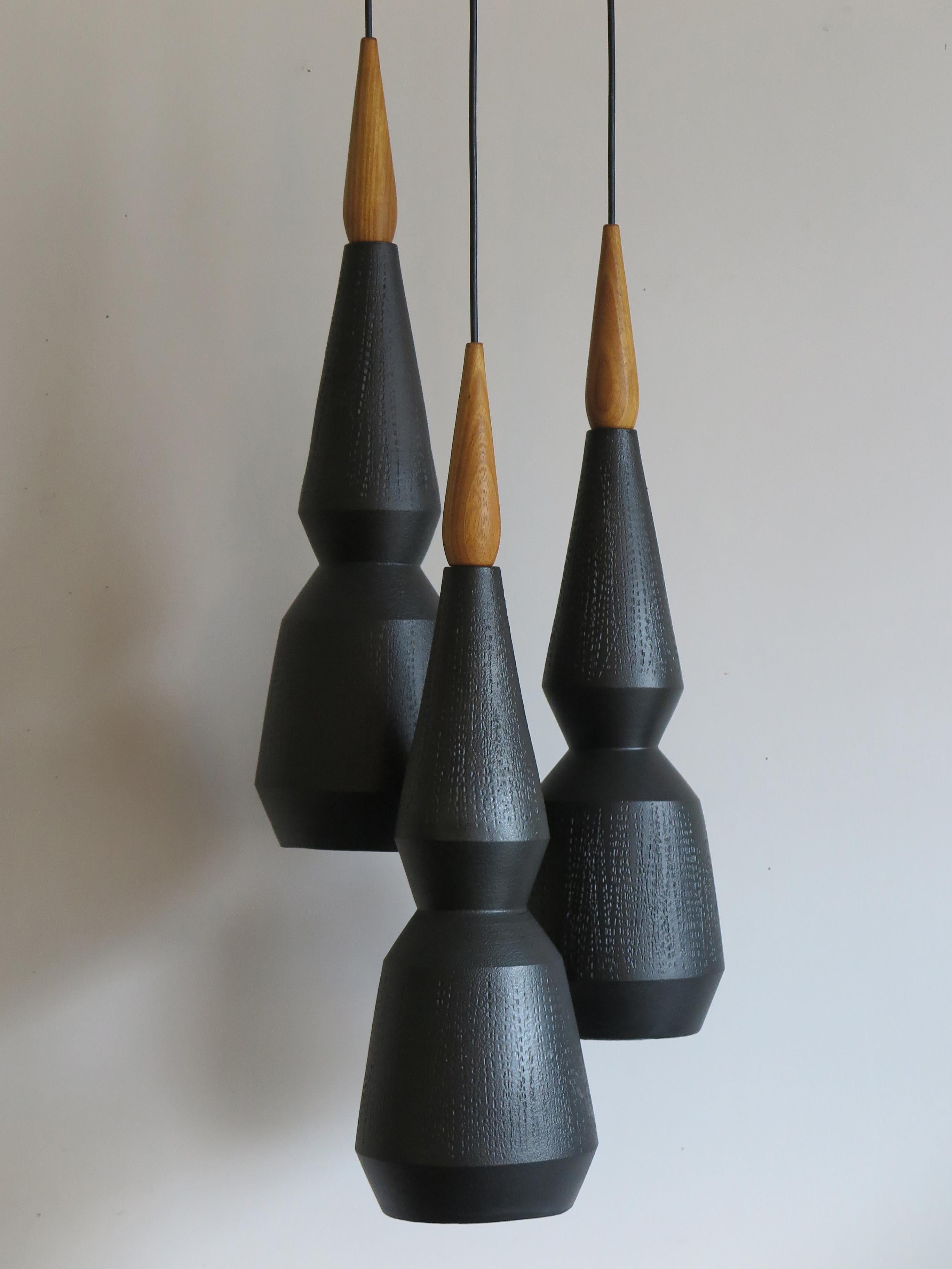 Set ceramic pendant lamps turned and hand-engraved with matte black enamel with wood details, contemporary design.
Single lamp measures: Height 68 cm, diameter 18 cm.