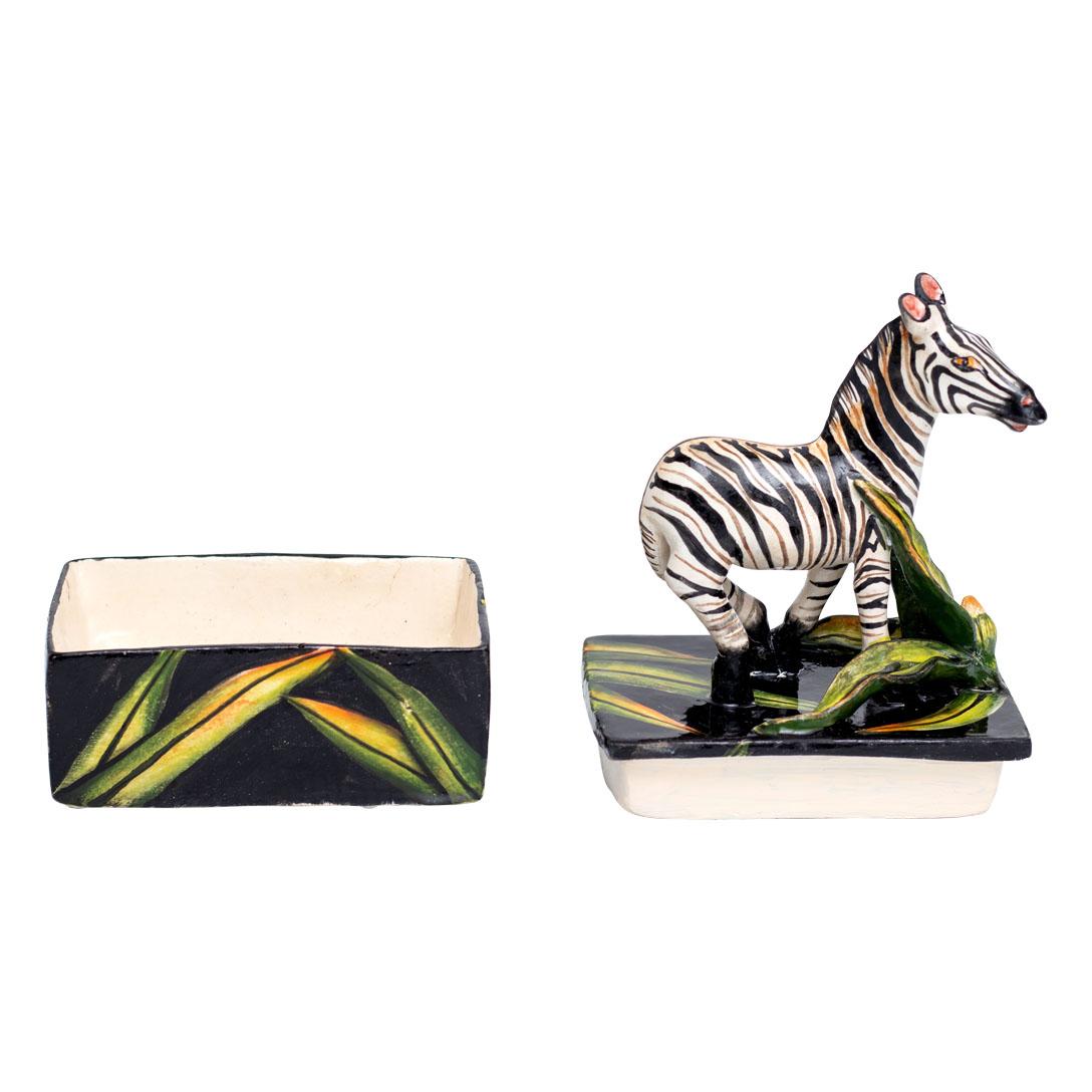This captivating ceramic zebra jewelry box is a striking example of South African craftsmanship and cultural artistry. Standing 6 inches high, 4 inches long, and 4 inches wide, this piece is a collaborative creation by sculptor Bennet Zondo and