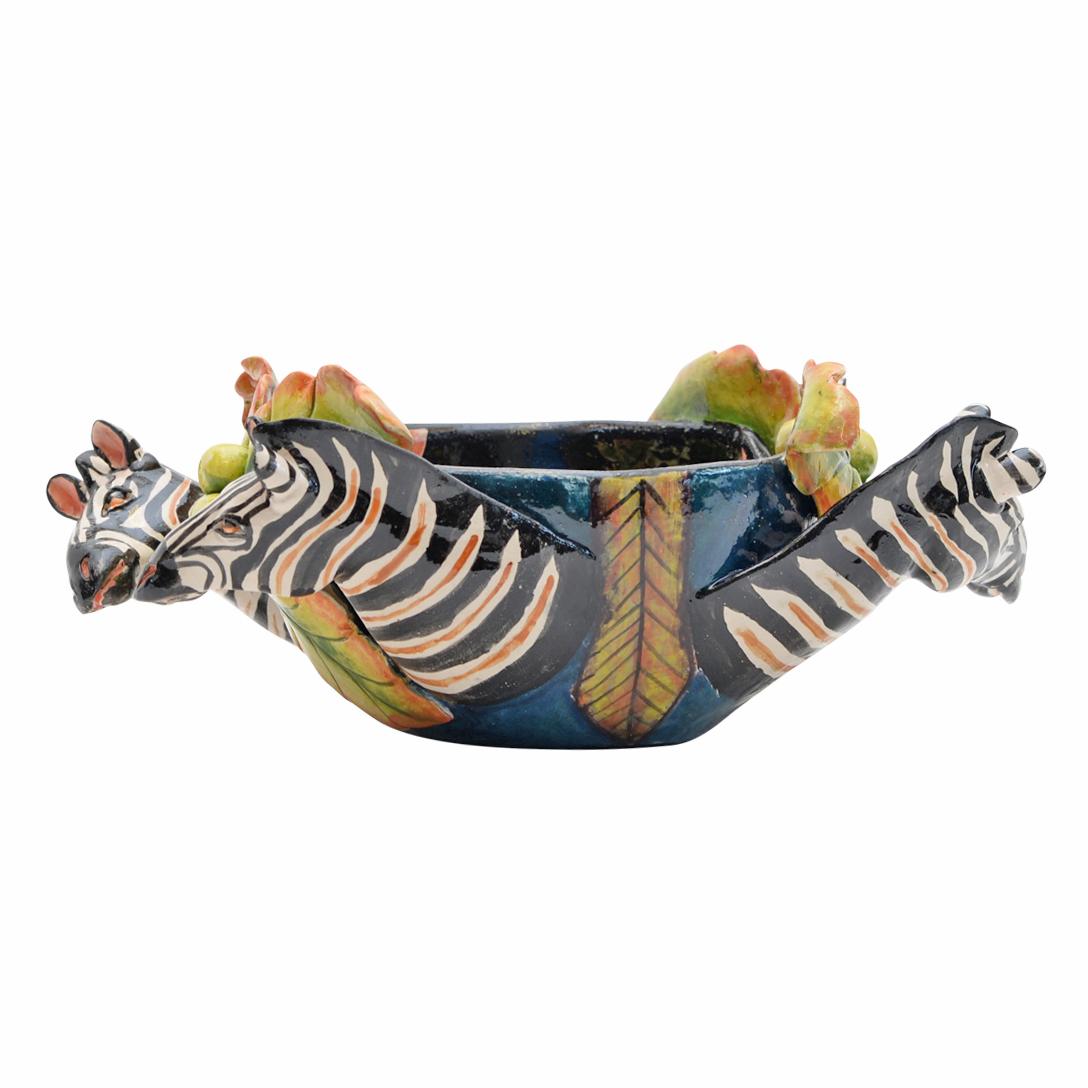 
Discover the Ceramic Zebra Peanut Bowl, a distinctive creation from Imvelo Natural Art, South Africa. Hand-sculpted by Teboho and hand-painted by Palesa, this bowl measures 5 inches in height, 8 inches in length, and 5 inches in width.

The bowl