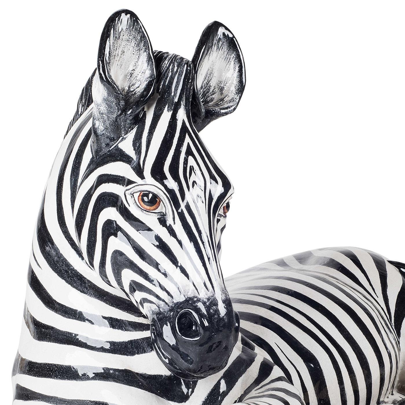 Un safari africano en la comodidad del hogar está mucho más cerca con esta estatuilla de cebra de cerámica. El animal -en reposo con las patas delanteras cruzadas de forma juguetona- está completamente decorado a mano en esmalte blanco y negro y es
