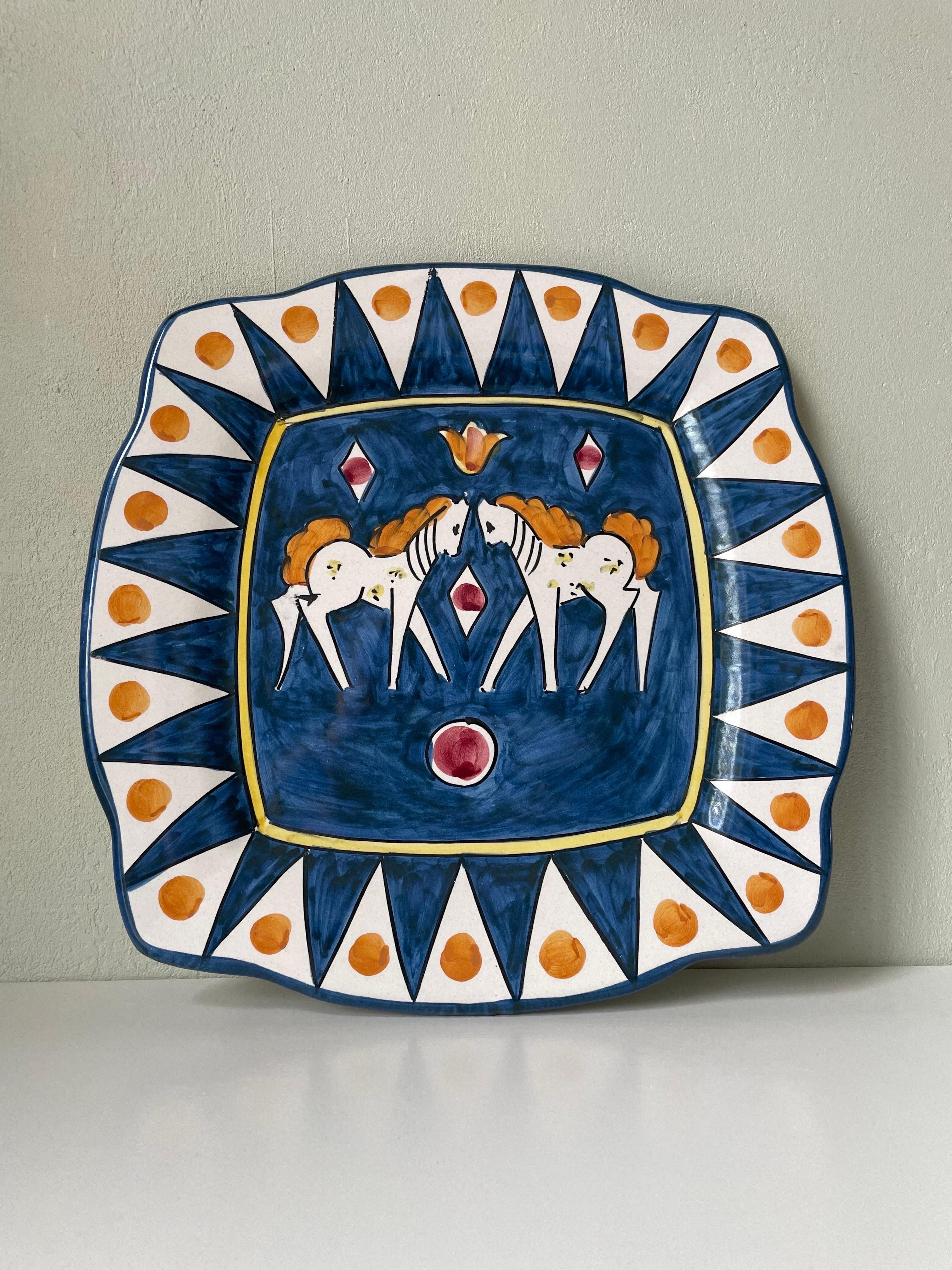 Hand-painted Italian modern soft cornered square shaped decorative dish, wall plate or center piece. Two white horses with orange manes and tails at the center. Crisp white and royal blue background and triangular decor with yellow and black lines