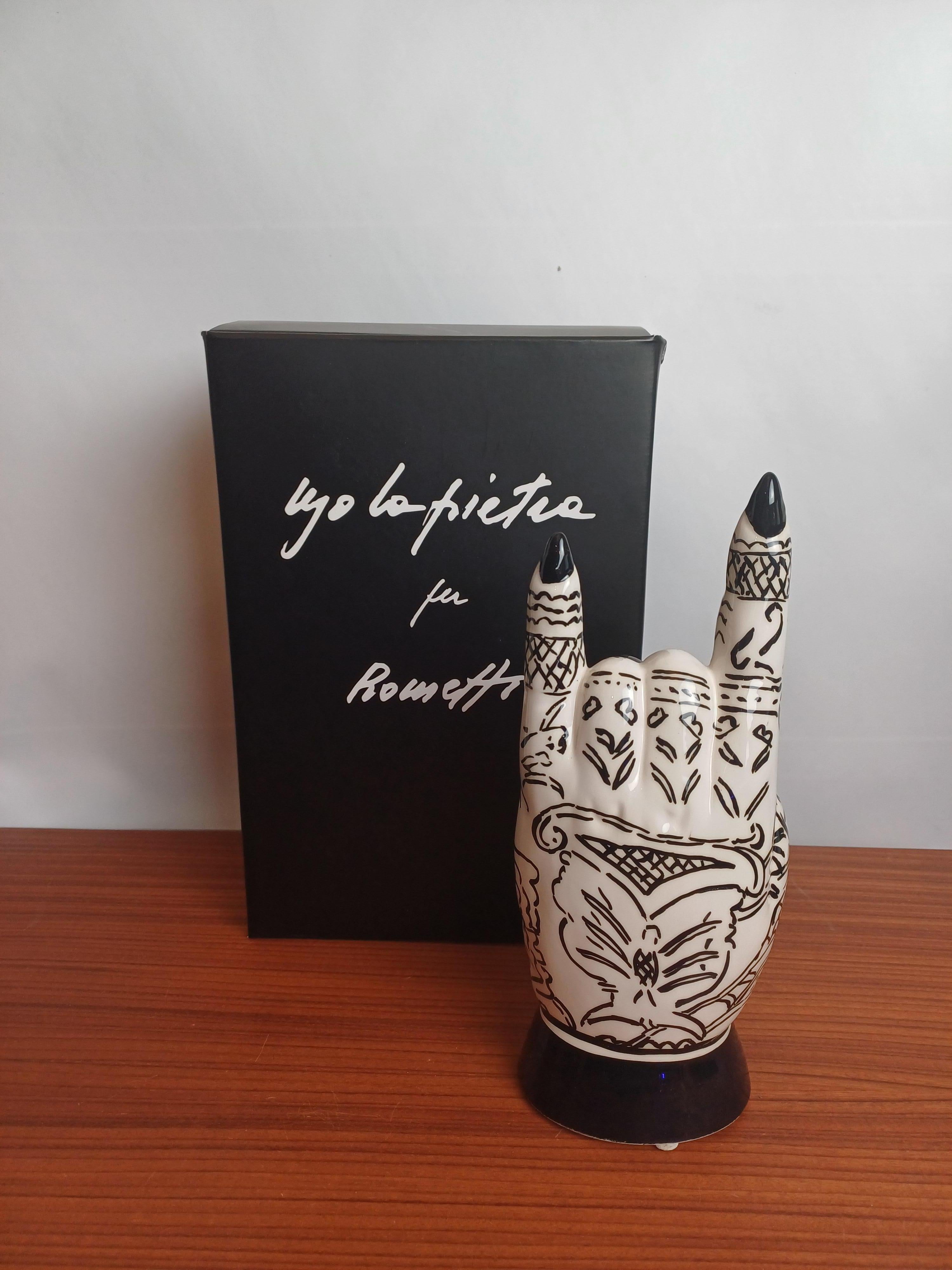 Keramische Hand entworfen von Ugo La Pietra im Jahr 2018 und produziert von Rometti ceramiche.
Keramische Hand mit ironischer und nonkonformistischer Tätowierung. Die Geschichte von Ceramiche Rometti begann am Ende der Jahre,  auch nach neunzig