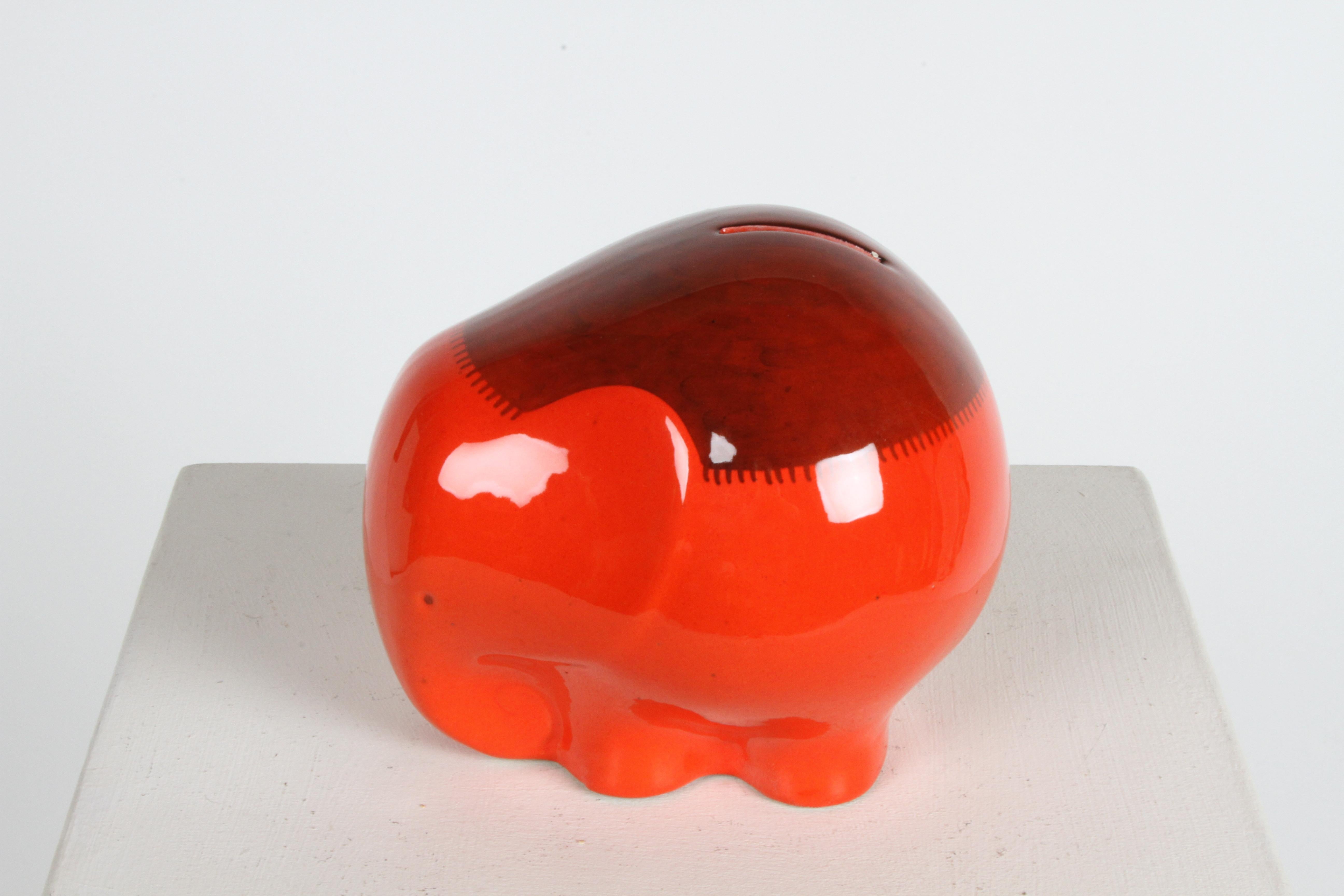 Whimsical mid-century elephant coin bank, money box or piggy bank from the Italian ceramics company Ceramiche Baldelli. Fired in a bright orange red glossy glaze, with hand painted fringe blanket on its back. Signed on bottom, Baldelli Italy 808. In