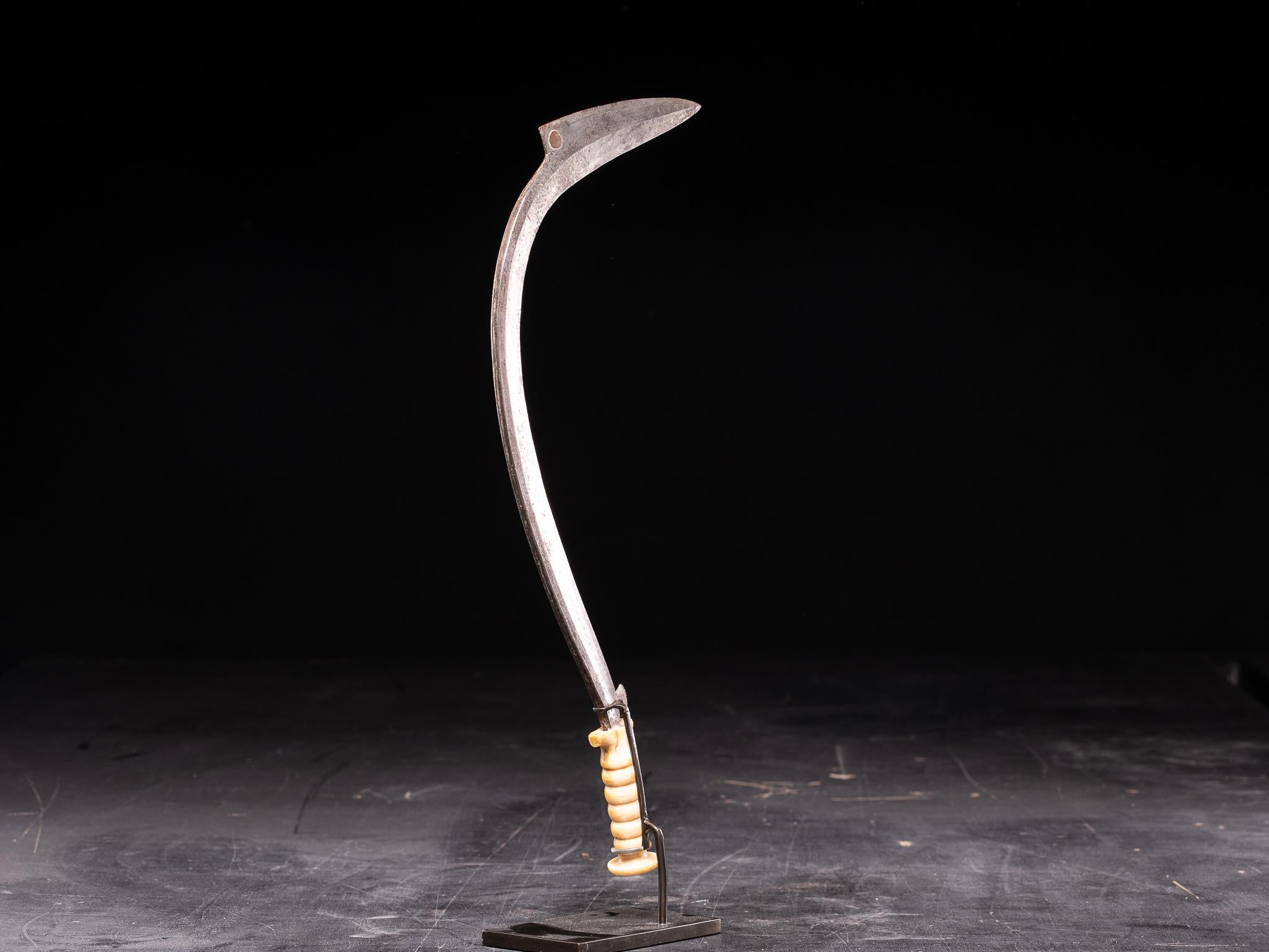 This elegant sickle knife with dull edges, red copper dot and ivory handle was not a war weapon but was made for prestige or ceremonial use by influential tribe members.