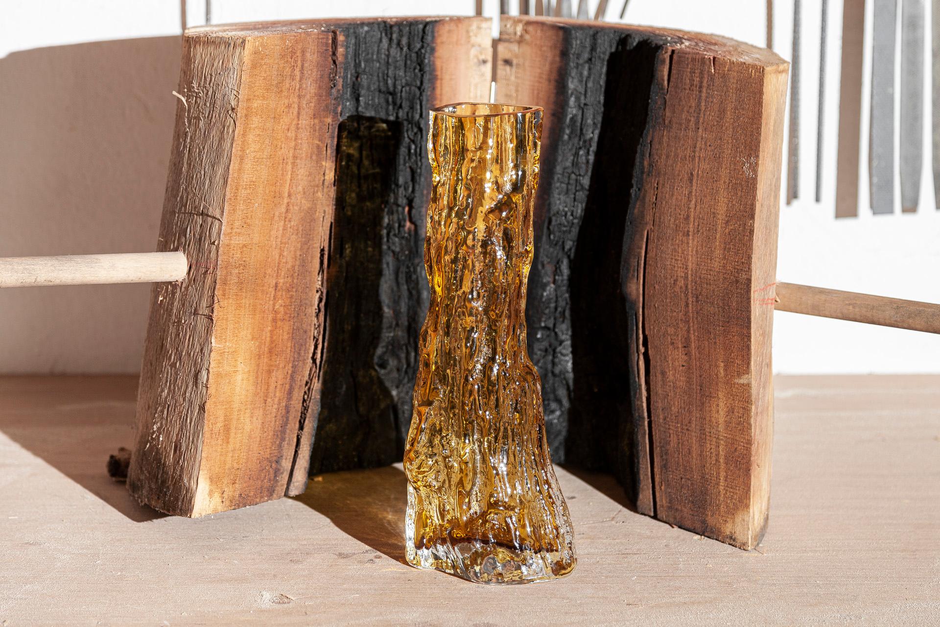 Cerne - che significa legno del cuore dell'albero - è il nome di questo vaso contemporaneo in vetro ambrato. Disegnata da Samuel Reis e realizzata a mano in Portogallo, Cerne prende forma soffiando il vetro in stampi cavi di tronco di carrubo. Il