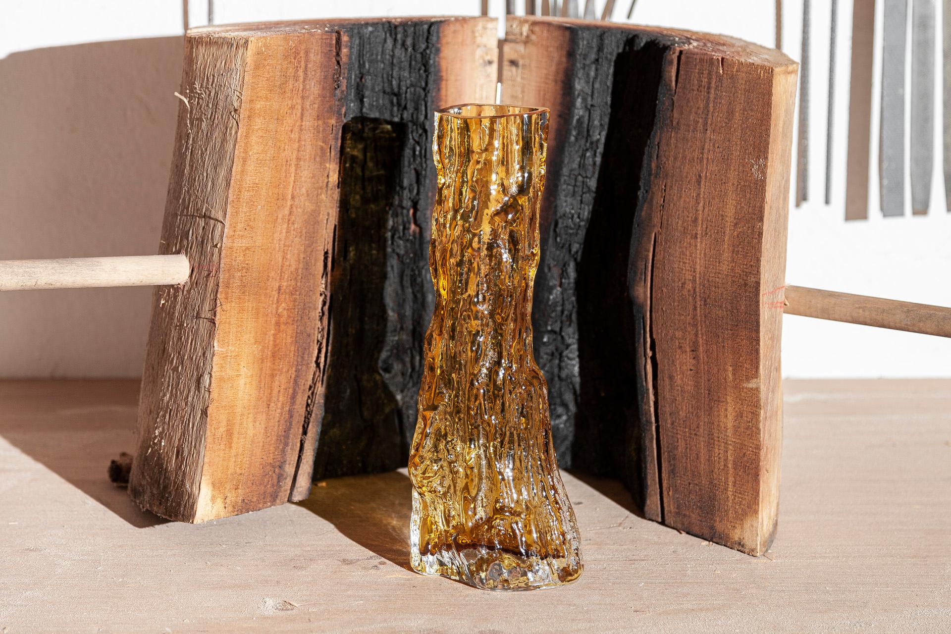 Cerne - meaning the tree's heartwood - is the name of this contemporary amber glass vase. Designed by Samuel Reis and handmade in Portugal, Cerne comes into shape by blowing glass into hollow carob tree trunk moulds. The final result is this glass