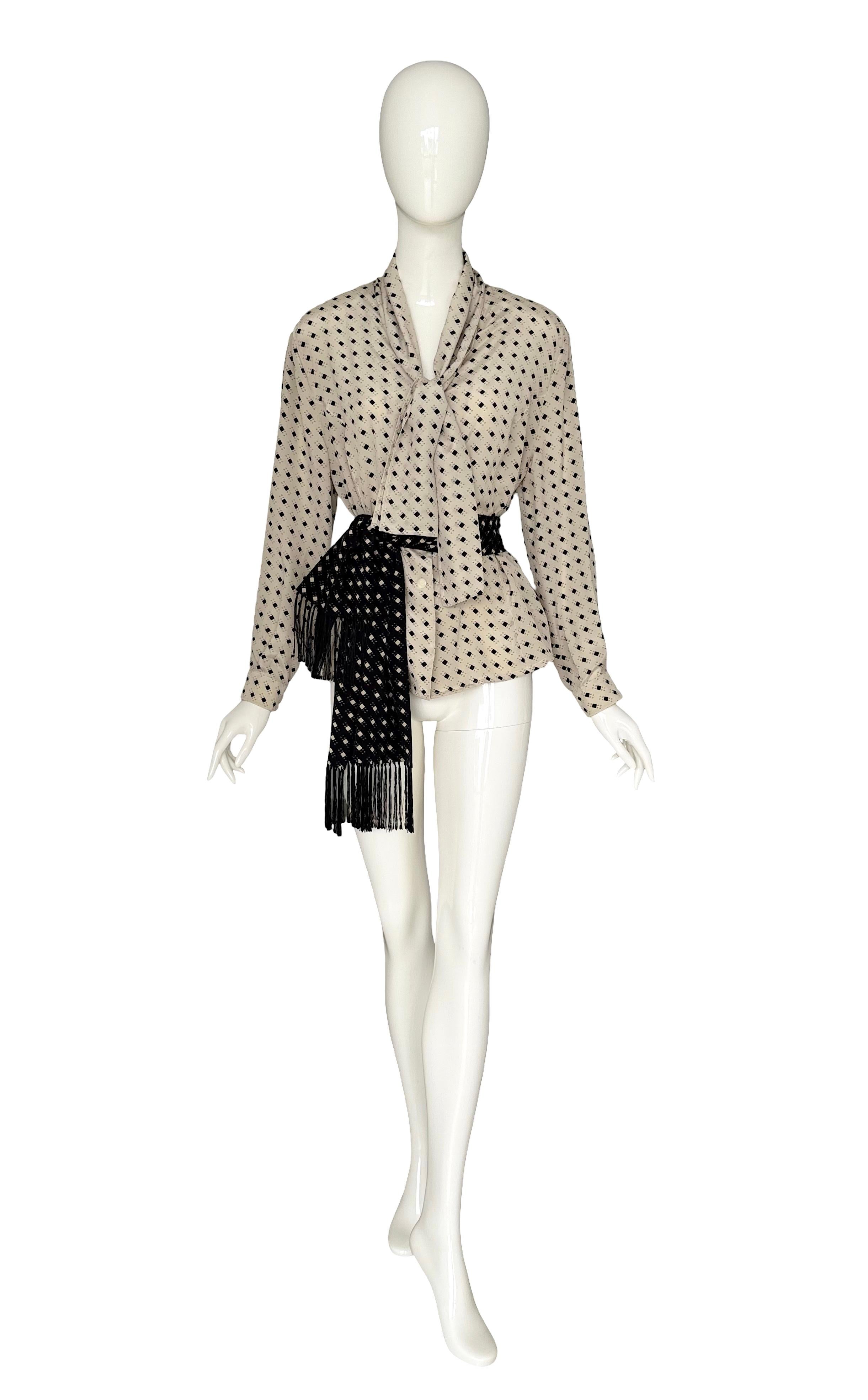 Eleva tu colección vintage con esta impresionante blusa de seda de los años 80 de Cerruti 1881, un ejemplo perfecto de lujo italiano y estilo atemporal. Confeccionada en pura seda, la blusa presenta un fondo crema con un estampado geométrico negro,