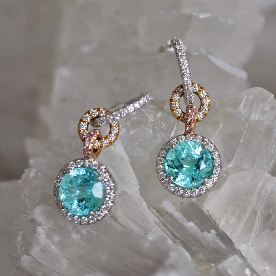 Un éclat dont on ne peut se détourner. Ces boucles d'oreilles présentent une époustouflante tourmaline de Paraíba, entourée de diamants blancs sur or blanc. La breloque est reliée à des maillons en or rose ornés de diamants roses fantaisie et à des