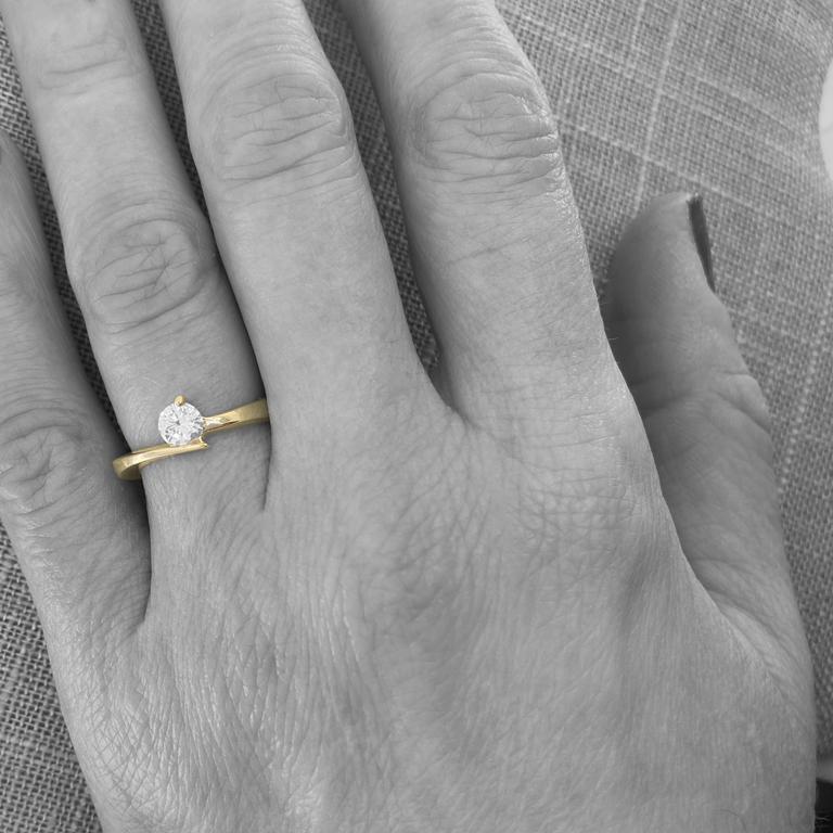 Wie ein Komet mit einem diamantenen Kopf und einem goldenen Schweif präsentiert sich dieser elegante und moderne Ring mit einem strahlend weißen Brillanten in einer raffinierten Einzelzahnfassung.  Der 