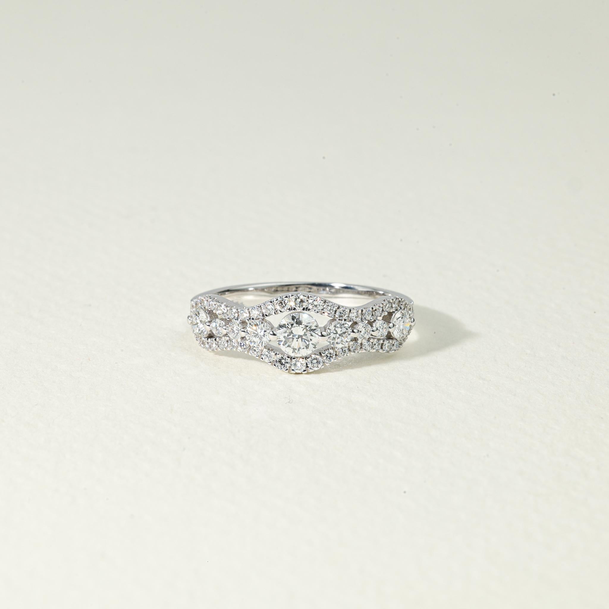 Celebrate love with luminous artistry in this exquisite cluster-style half eternity engagement ring, a refined symbol of elegance, romance, and radiant devotion. Meticulously handcrafted in 18K white gold, this captivating piece features a 0.85ct