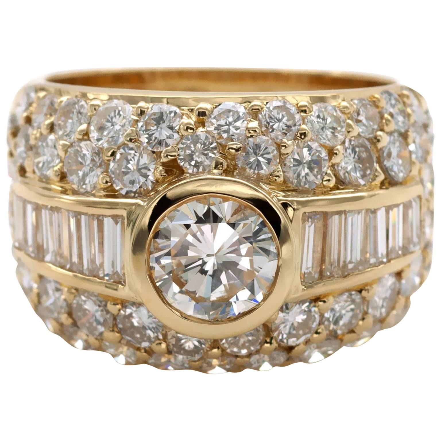 Classy cocktail ring: A genorous  18KT gold band softly domed pave set with round diamonds . In it center in a polished yellow gold frame A bezel set HRD certified center diamond and on each side of wich six bagette cut diamonds.
Center diamond :