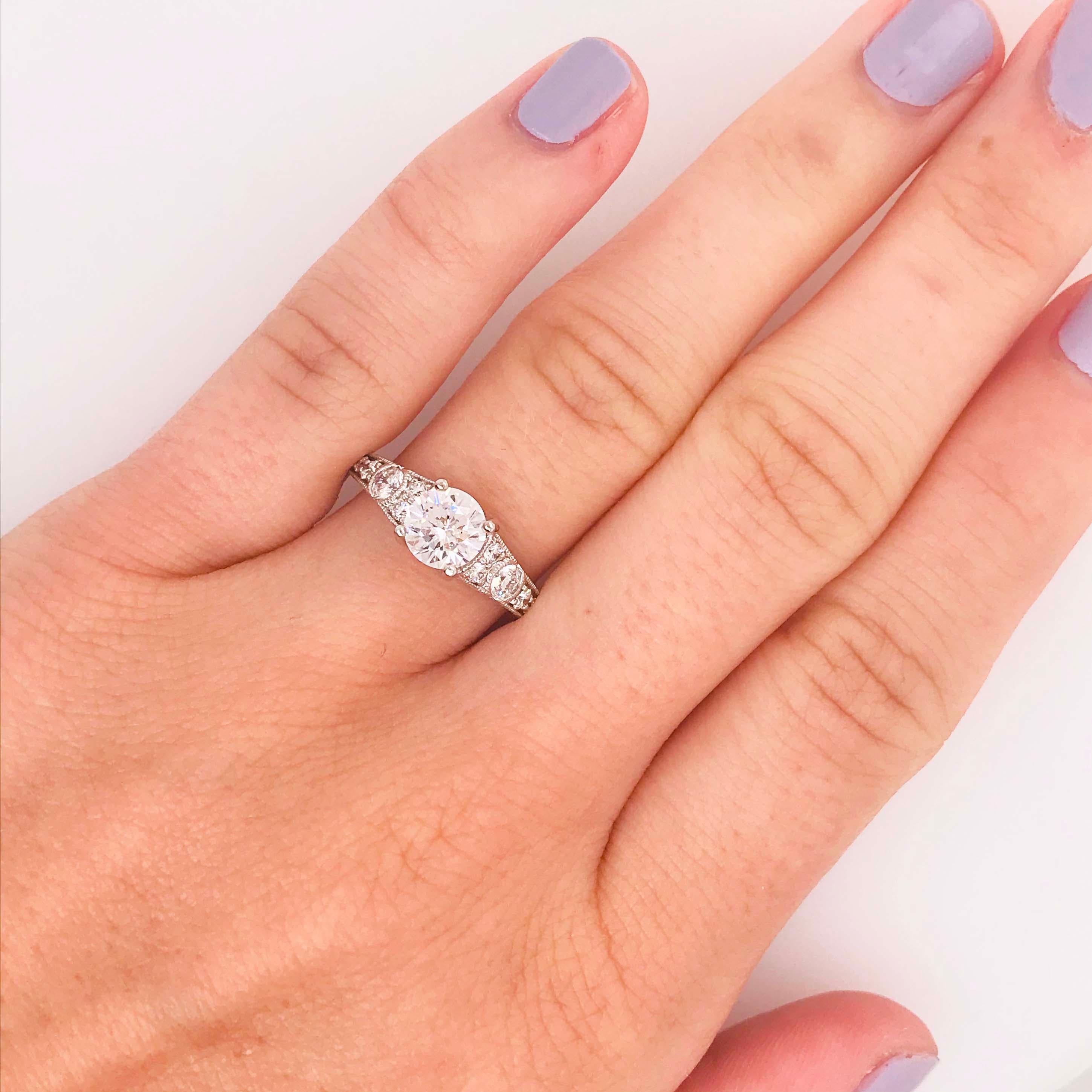 This vintage styled diamond engagement ring has a 1.01 carat round brilliant, Hearts & Arrows diamond set in the center! The 14 karat white gold, vintage/antique designed ring has the most beautiful and intricate design with diamonds going half way