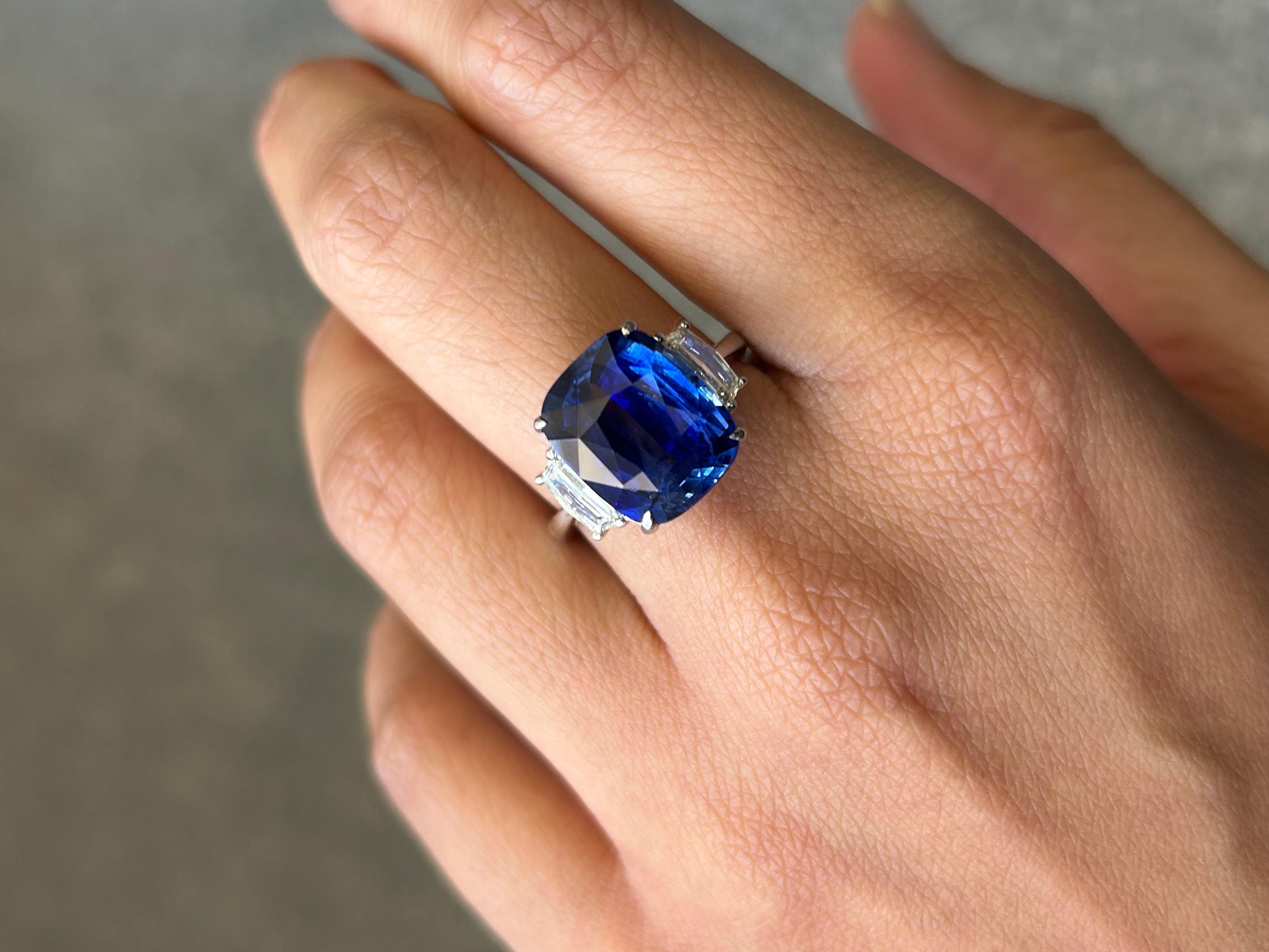 A stunning 10.04 carat certified natural, cushion shaped Ceylon Sri Lankan Blue Sapphire, royal blue color and transparent with great luster/shine . The center piece is adorned with 0.58 carat Cadillac shaped side stone Diamonds, VS quality, G