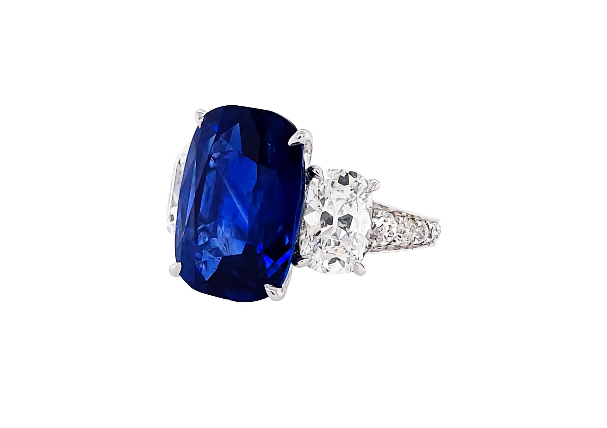 This ring is a rare find. It is featuring a 10.58 carat cushion blue sapphire, two cushion diamonds on both sides and pave diamonds half-way down the band. 
The sapphire is certified by AGL stating that it's of Ceylon origin with no indication of