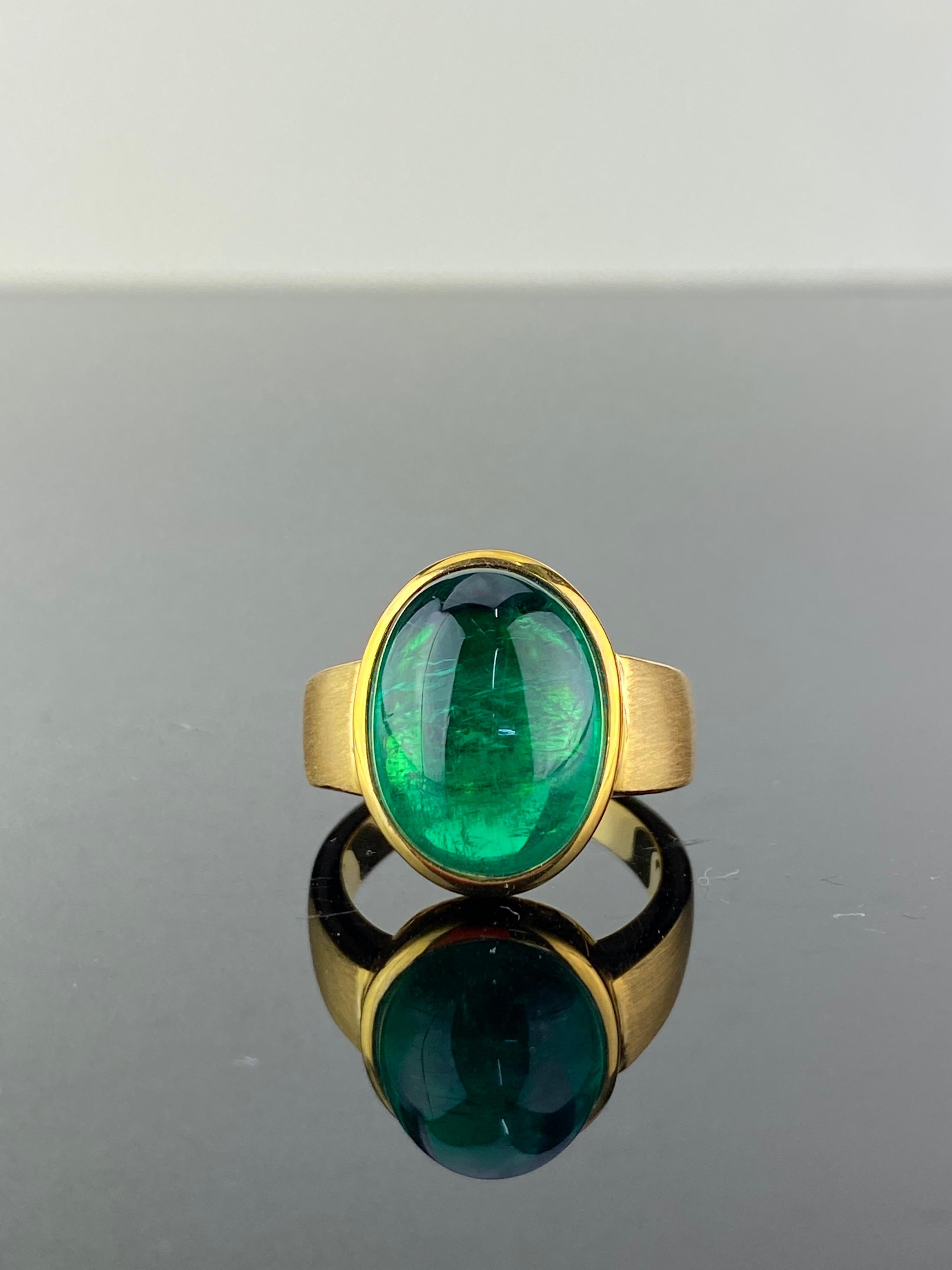 An absolutely stunning 10.87 carat Zambian Emerald cabochon and matte finish 18K Yellow Gold ring. The natural Emerald centre stone is completely transparent with an ideal vivid green color and is of a very high quality, and the matte finish gold