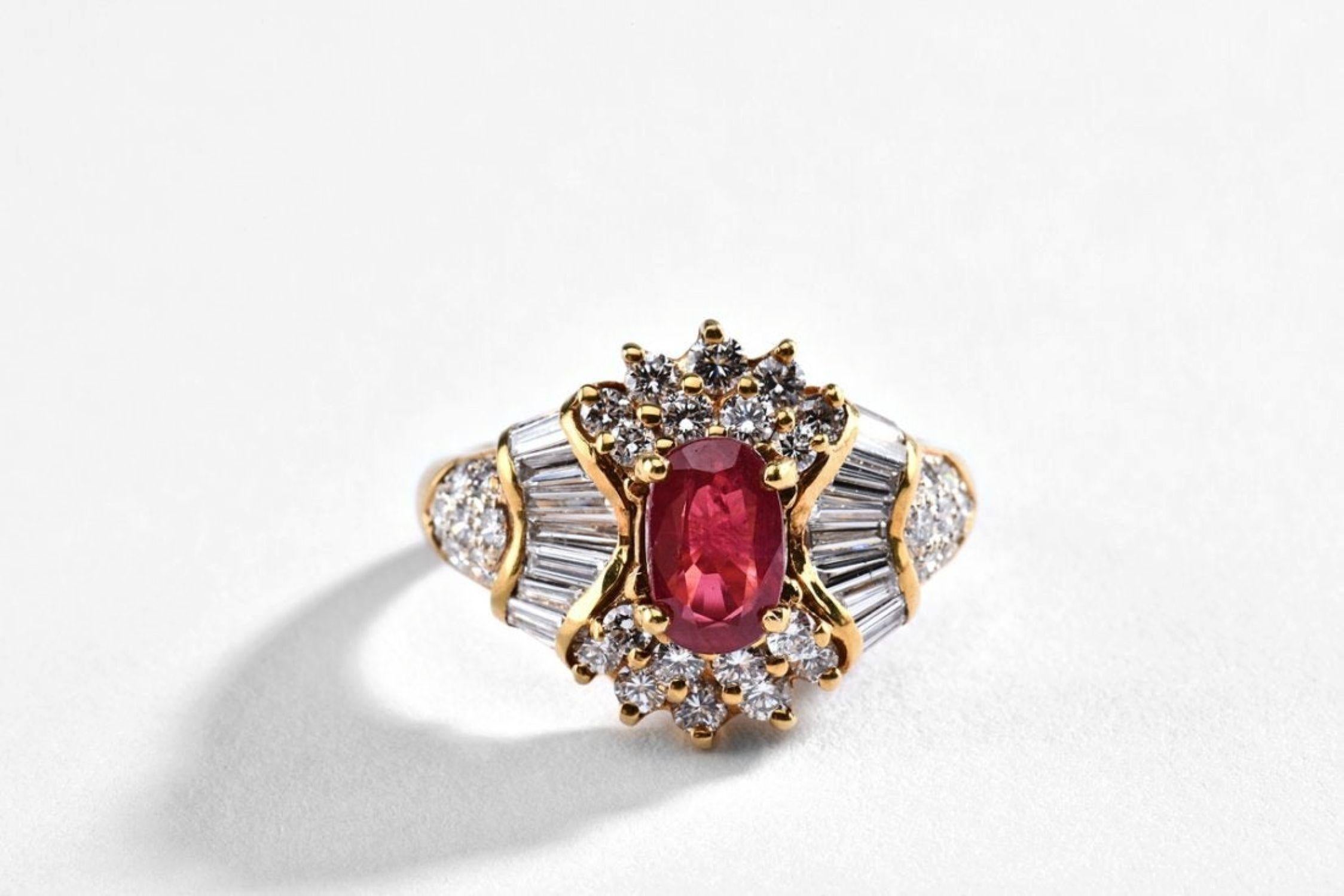 Al centro di un rubino naturale di forma ovale del peso di circa 1,21 carati, questo anello presenta diamanti naturali affusolati a baguette e rotondi incastonati in una montatura in oro giallo 18 carati. L'anello misura circa 6 ed è accompagnato da