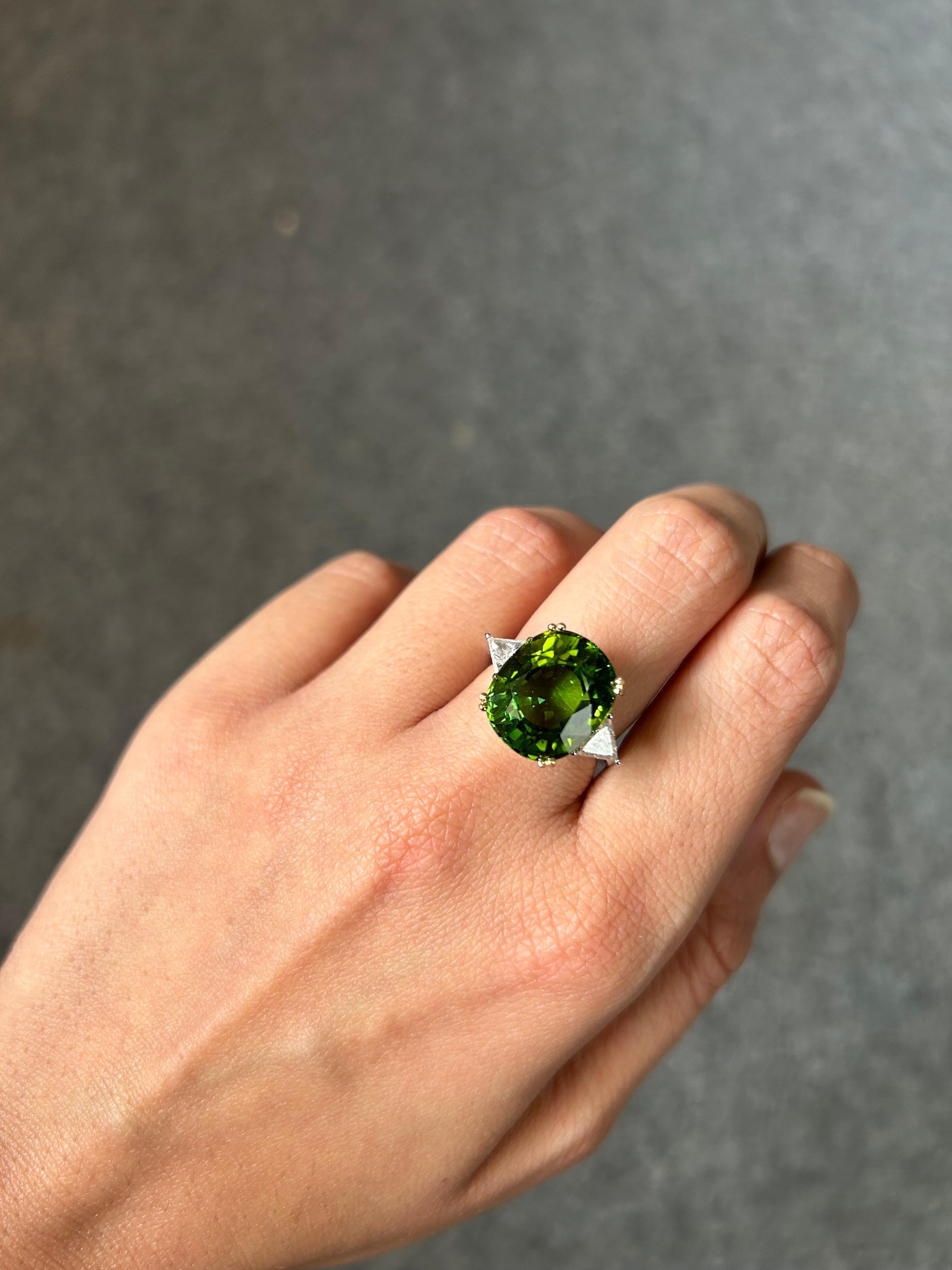 A stunning 12.34 carat Tourmaline and 0.67 carat VS quality White Diamond three stone engagement ring, set in solid 18K White Gold. The center stone is natural, with no inclusions at all, and has a great luster to it, with an ideal green color. The