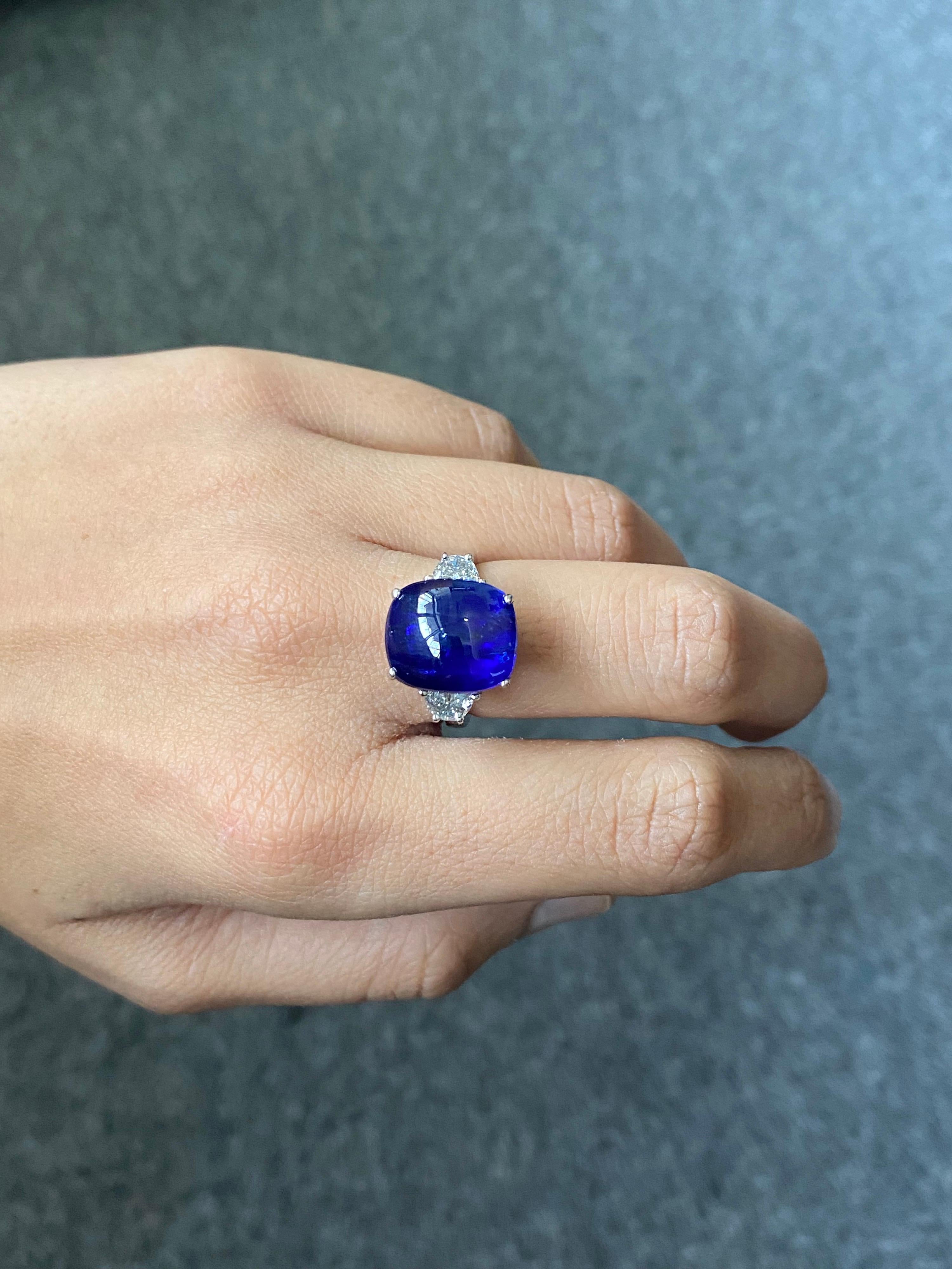 A beautiful, Ceylon Blue Sapphire and Diamond three-stone engagement ring set in solid 18K White Gold. With a 13.35 carat cushion shaped Sapphire in the centre, with half-moon White Diamonds on the side. The Sapphire is transparent, with a beautiful
