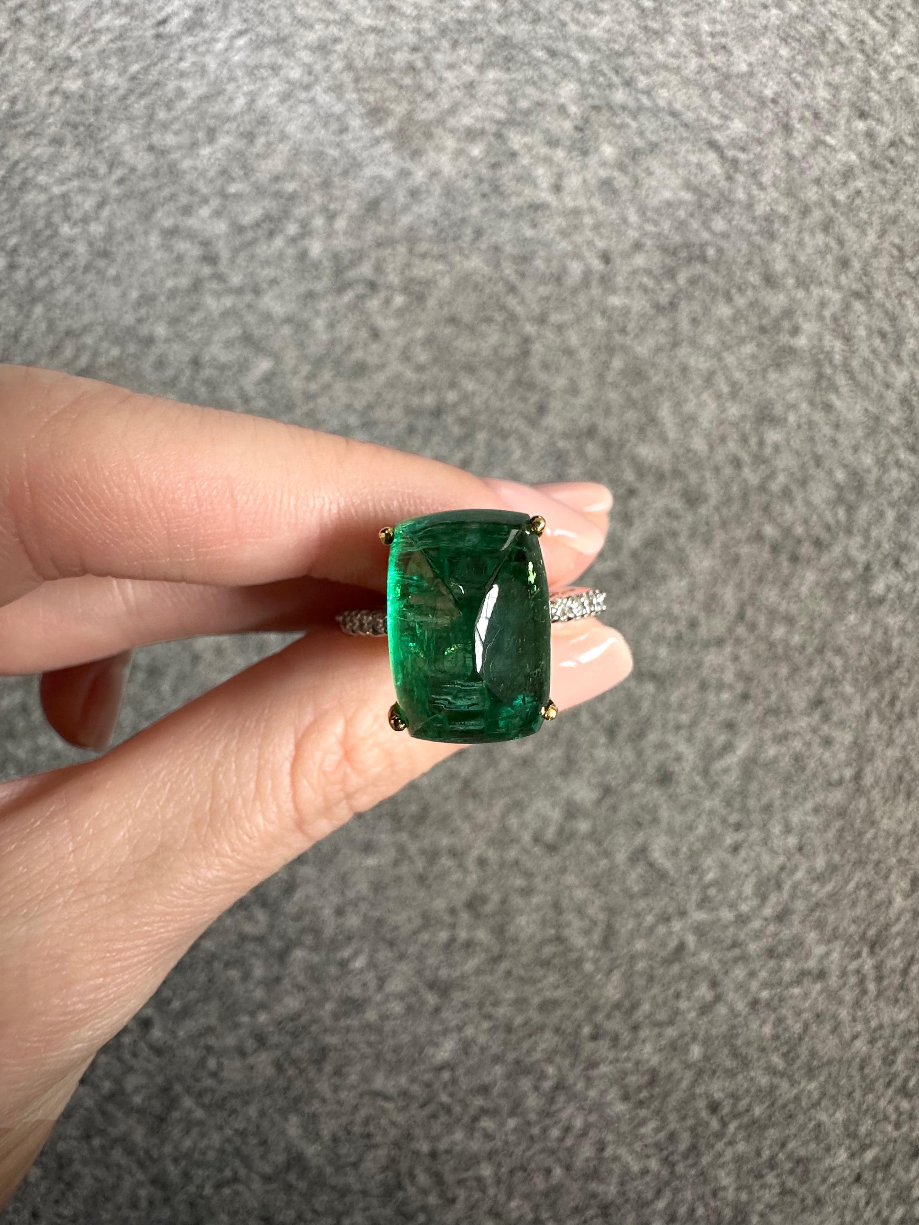 Make a statement with this stunning, certified, natural 13.40 carat Emerald sugarloaf shaped cocktail ring. The center piece is absolutely transparent, with a beautiful vivid green color. The ring is set in solid 18K white gold, and is sized