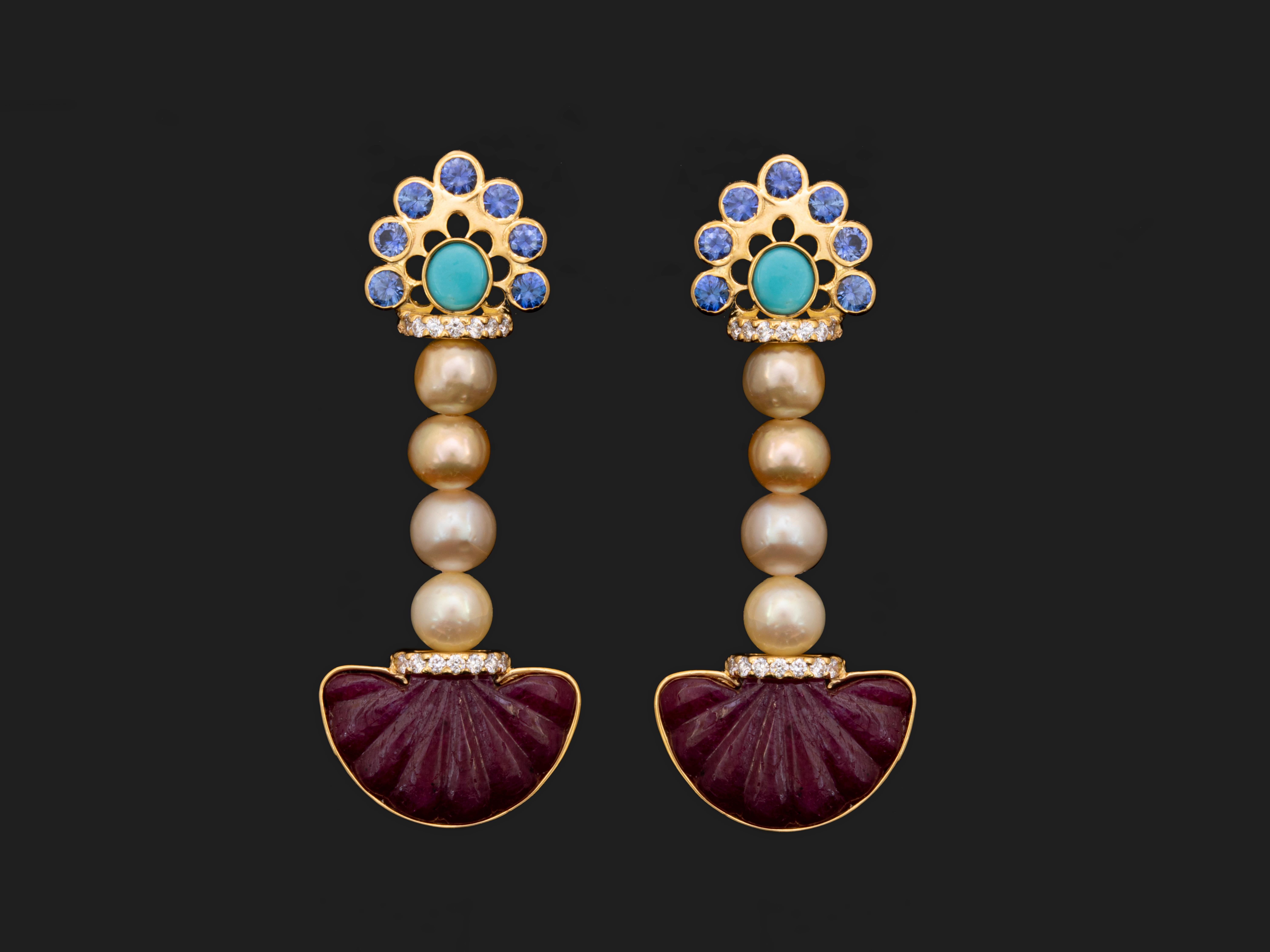 Pendulum earrings celebrating color.
14 ct. of semi round multi colored Pinctada Radiata pearls hang beautifully in-between carved ruby pendulums and  18k yellow gold motifs studded in blue sapphire and turquoise gems.


Gold Weight: 7.27 g
8 Pearls